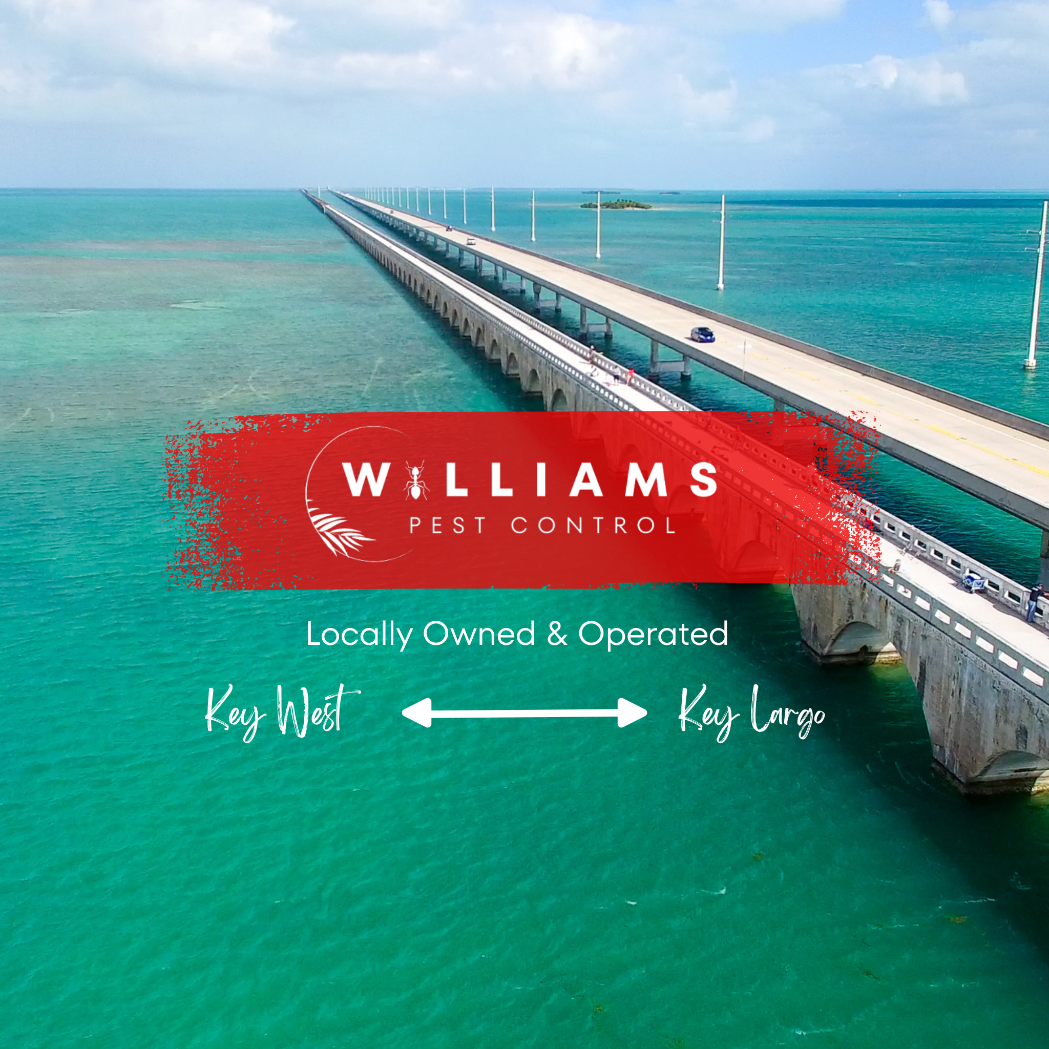 A bridge over bright turquoise water extending into the distance with a small island nearby. The bridge has streetlights and a few cars visible, with another smaller bridge connected at the near end. The sky is partly cloudy.