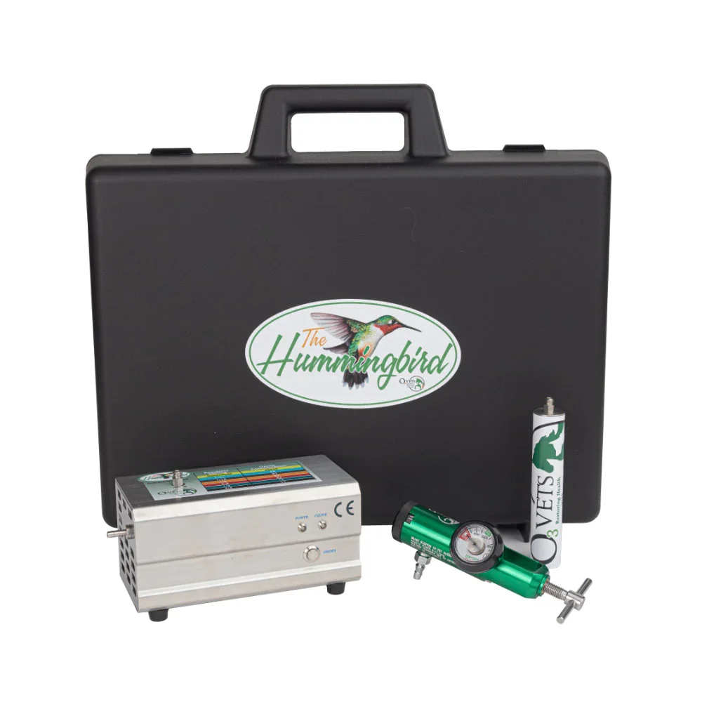A black carrying case with the logo of a hummingbird on it, along with a portable vaporizer, a butane gas cartridge, and a battery or charger, used for outdoor use.