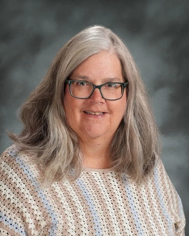 A school crest with religious symbols and a female figure with a halo, and the phrase 'Coming Soon' below.