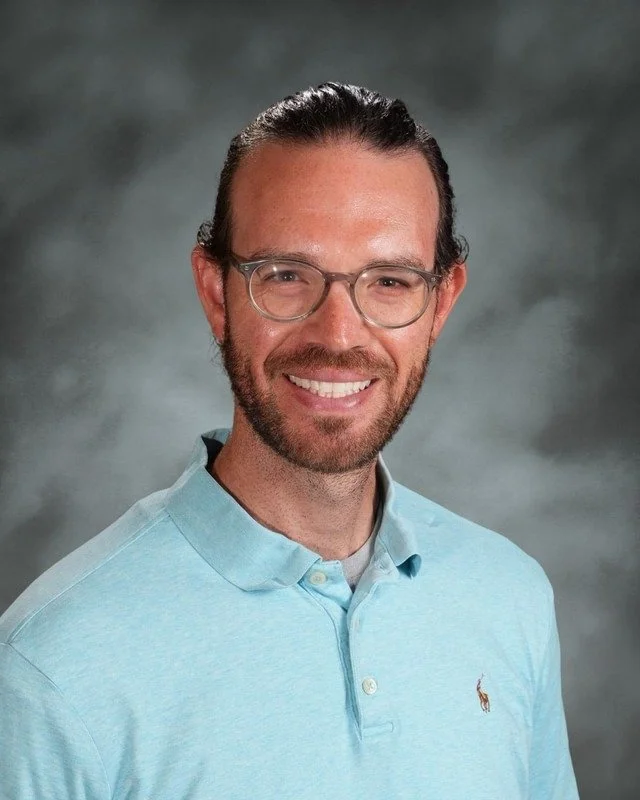 A shield emblem with religious symbols, a woman's face, and a dove, with a banner saying "Adora Disce Serve" and the year 1983, above the text "Coming Soon."