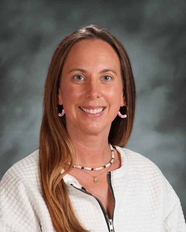 A crest shield with religious symbols, a haloed woman, a rolled scroll, and a dove, with a banner reading "Adora Disce Serve" and the year 1983, and the text "Coming Soon" below.