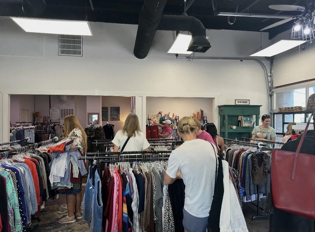Shoppers browse racks of donated clothing on the expanded sales floor at UpStart Thrift in Farmington, Arkansas