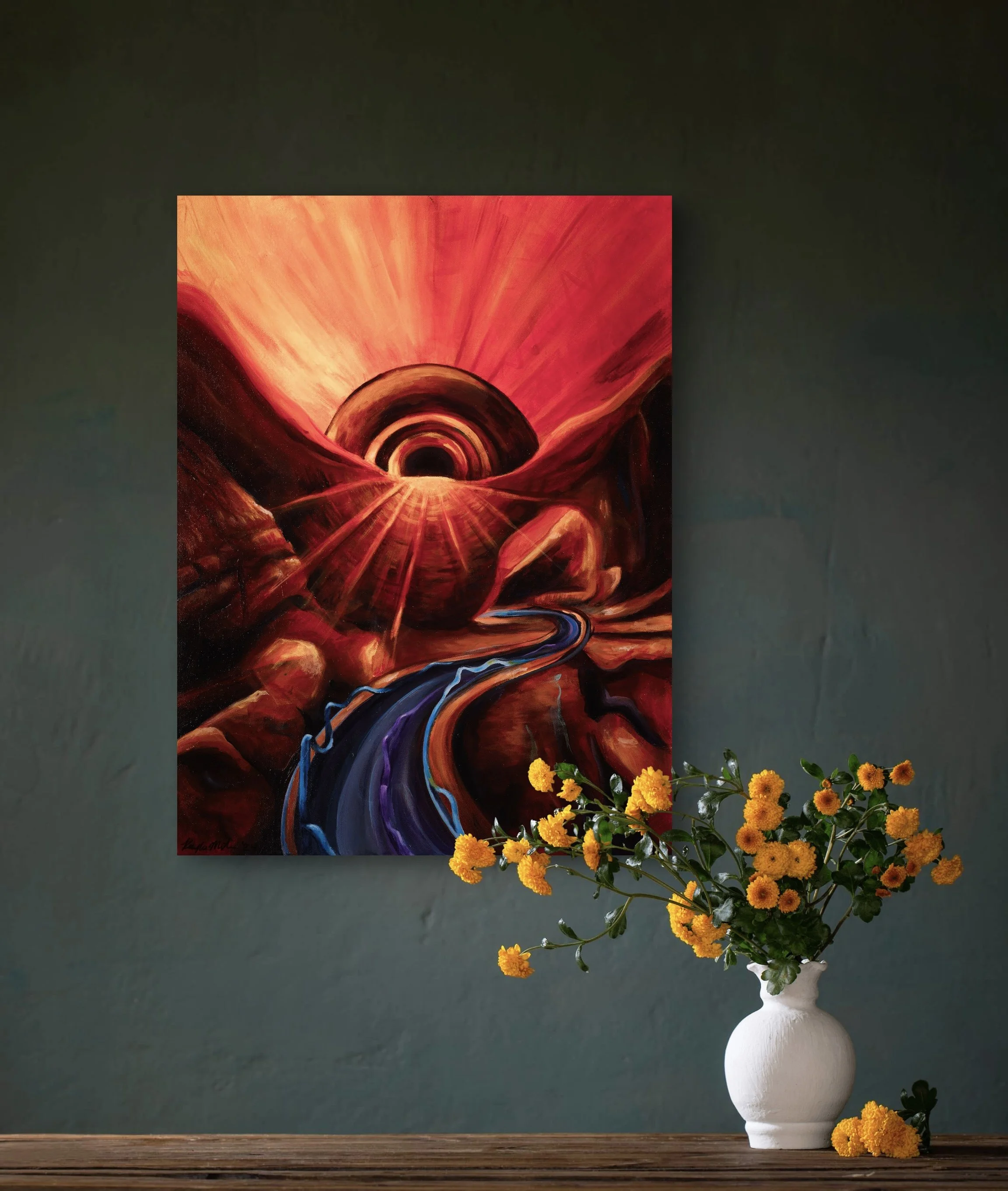 A vibrant abstract painting with a tunnel-like design in red, orange, and purple hues, hanging on a dark green wall above a wooden table with a white vase filled with yellow flowers.