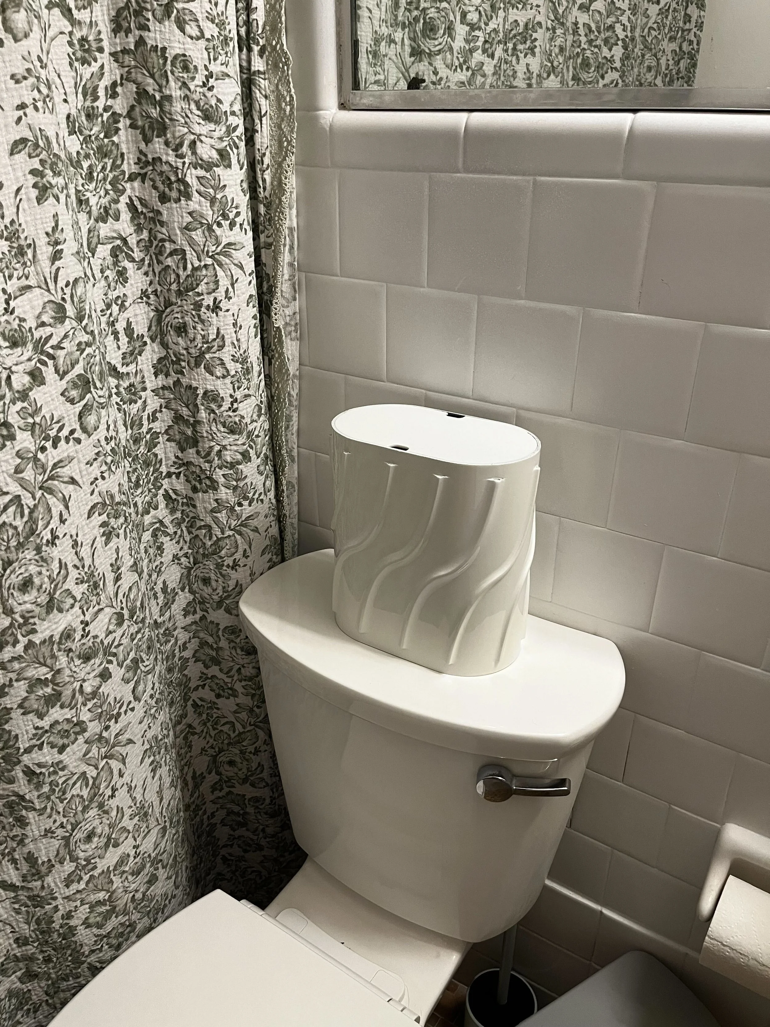 Image of the at-home Deleon Technologies metabolomics testing system, called the Otea. The Otea is placed on top of a toilet. The Otea is small and white. Source: Deleon Technologies.