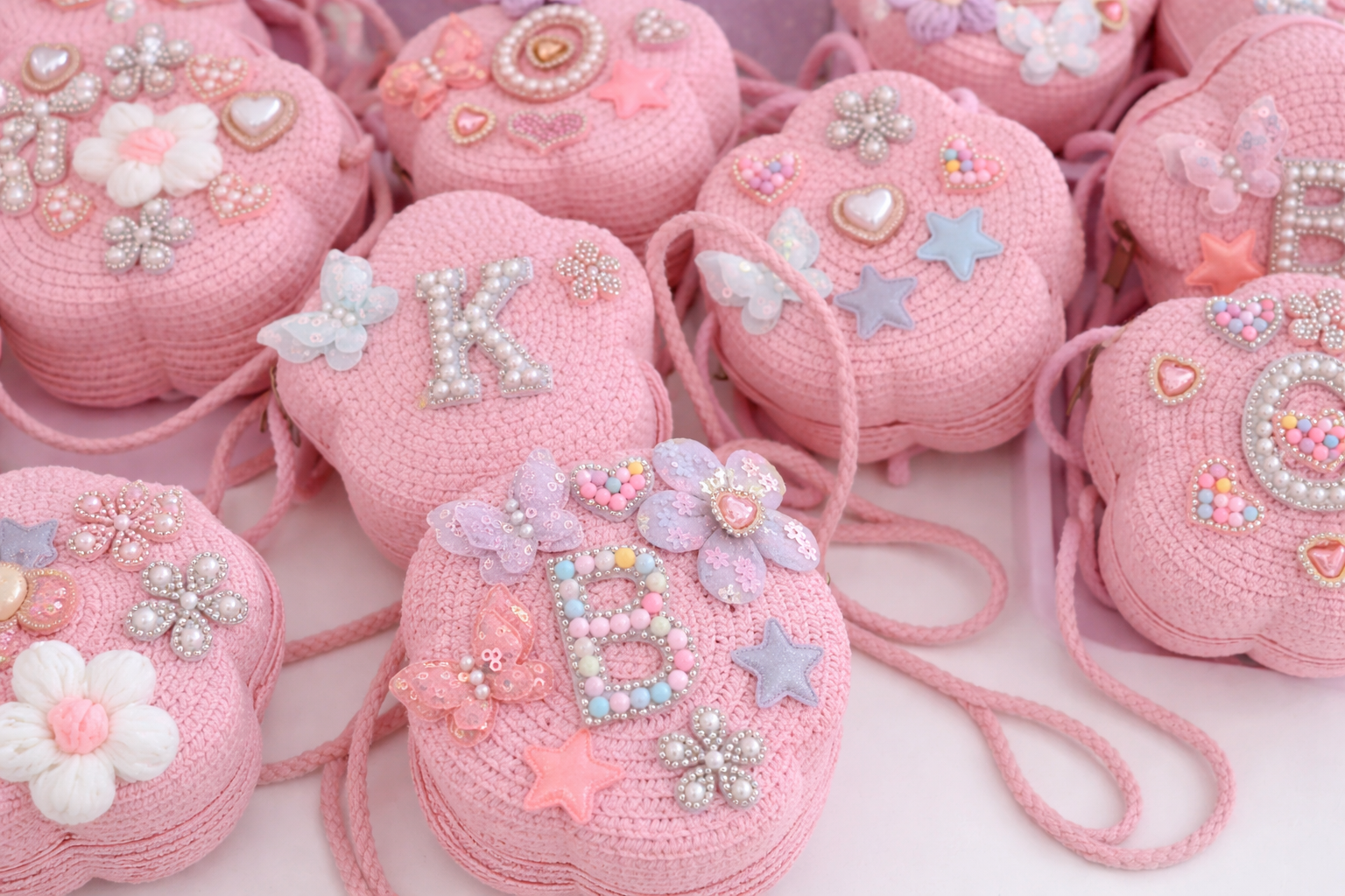 Pink mini purses featuring personalized pearl initials and pastel embellishments. These custom keepsakes were designed by guests as part of  Blush & Bliss by Mya’s entertainment stations and experiences for kids’ birthday parties, teen birthday parti