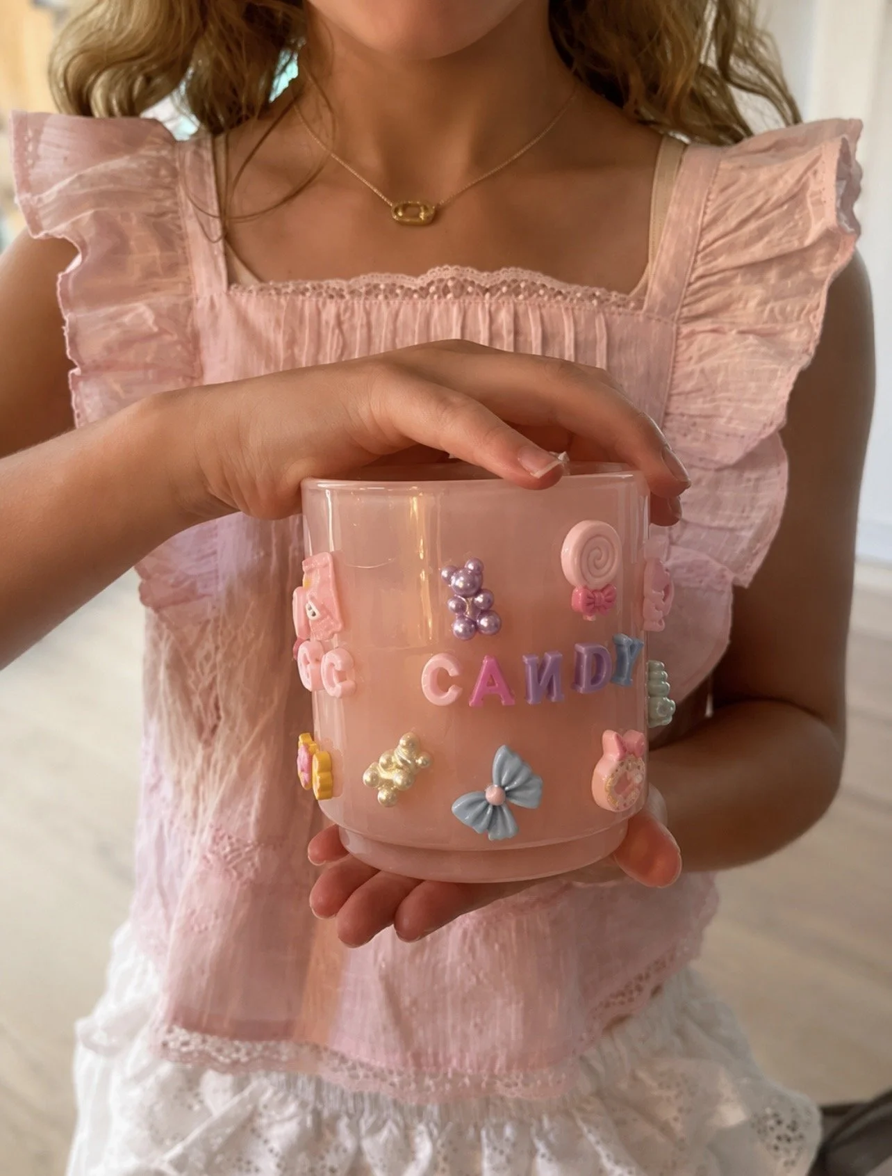 Teen girl holding a candle she bedazzled with charms at a birthday party in Libertyville with Blush & Bliss by Mya party entertainment.