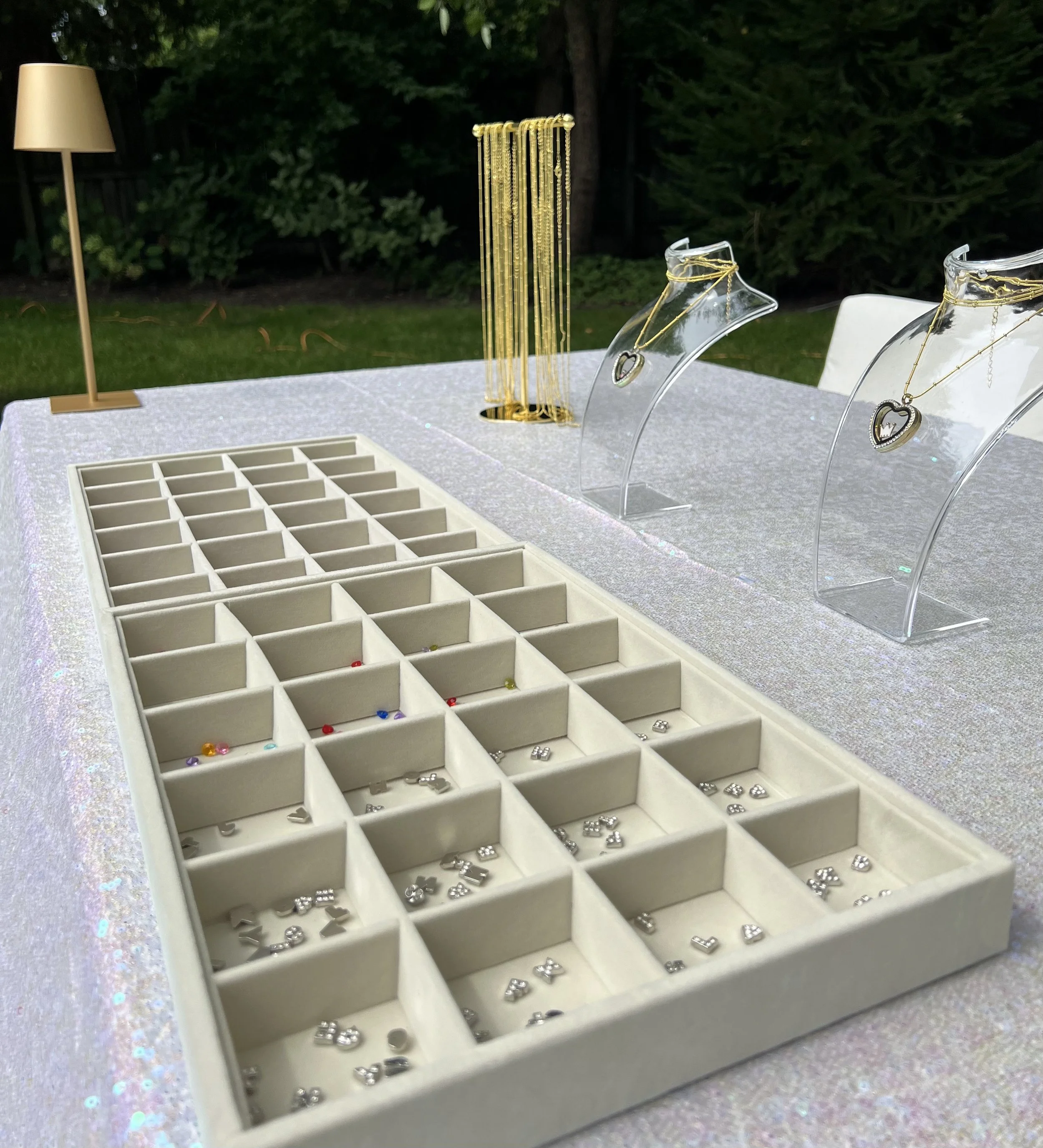 Close-up of a custom Floating Locket Necklace Bar with miniature charms, gold chains, and heart lockets, an interactive jewelry experience for Bat Mitzvahs, Sweet 16s, birthdays, and private events in Chicago.