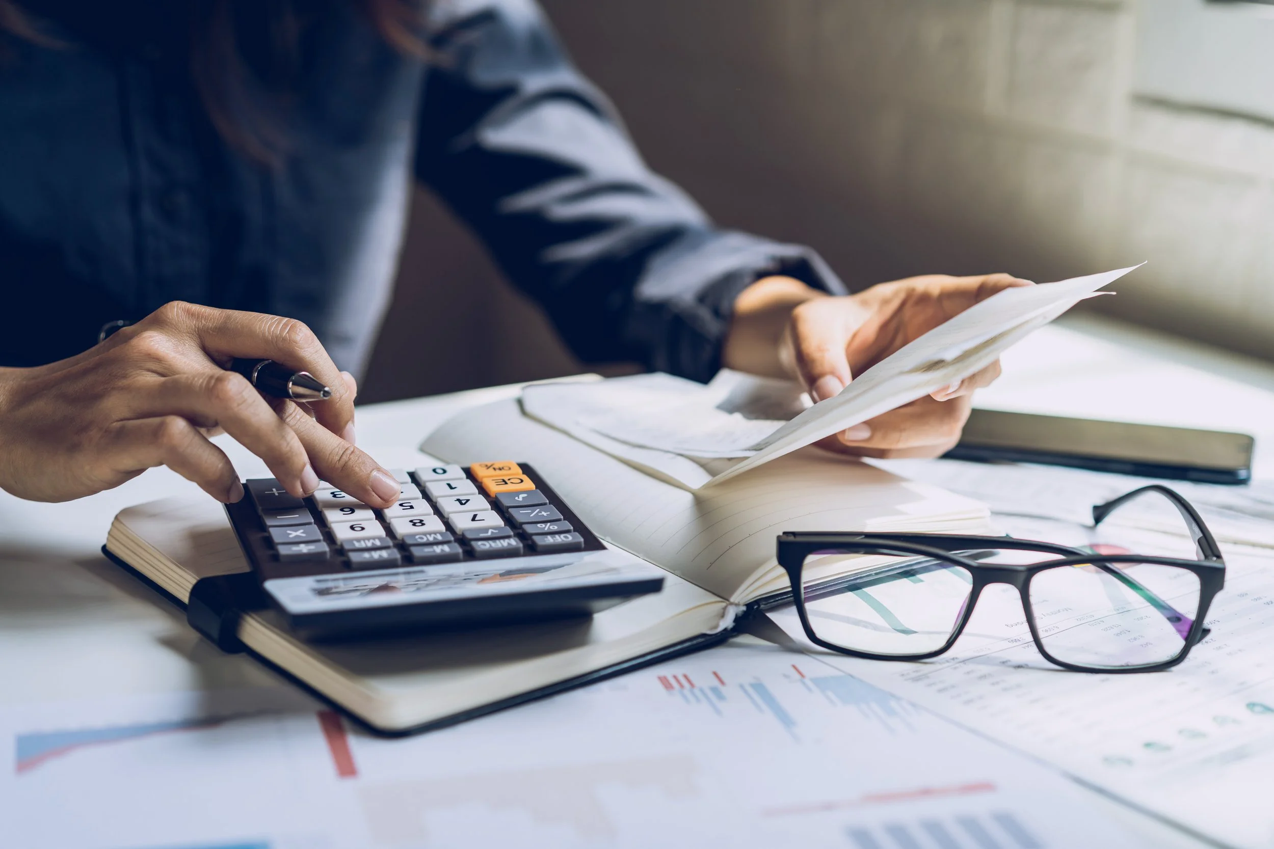 Tax documents and a calculator on a desk during retirement planning.