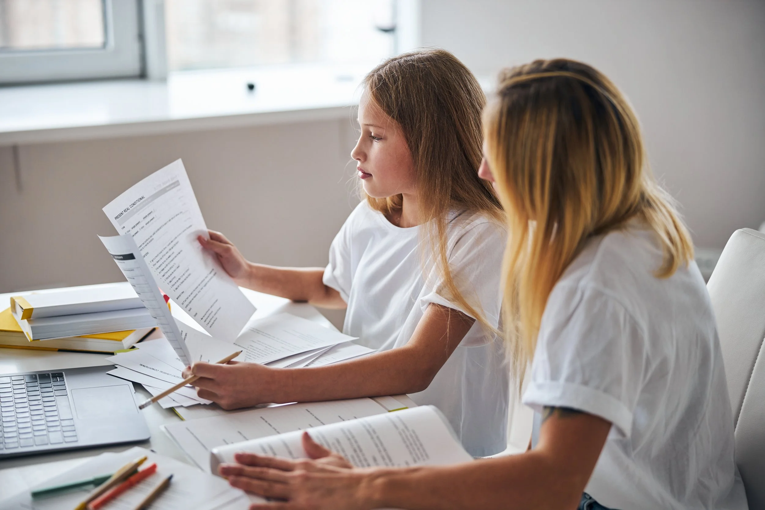 A parent and college student reviewing an insurance policy together at home.