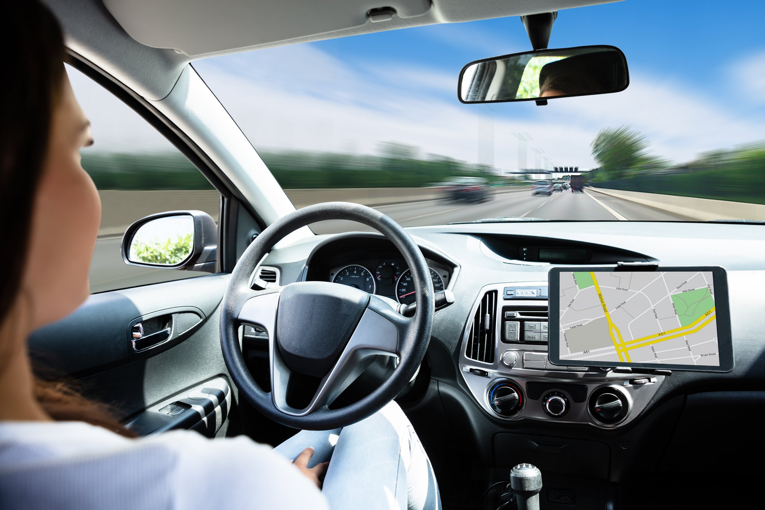 Autonomous vehicle with sensor technology driving on a highway alongside regular traffic