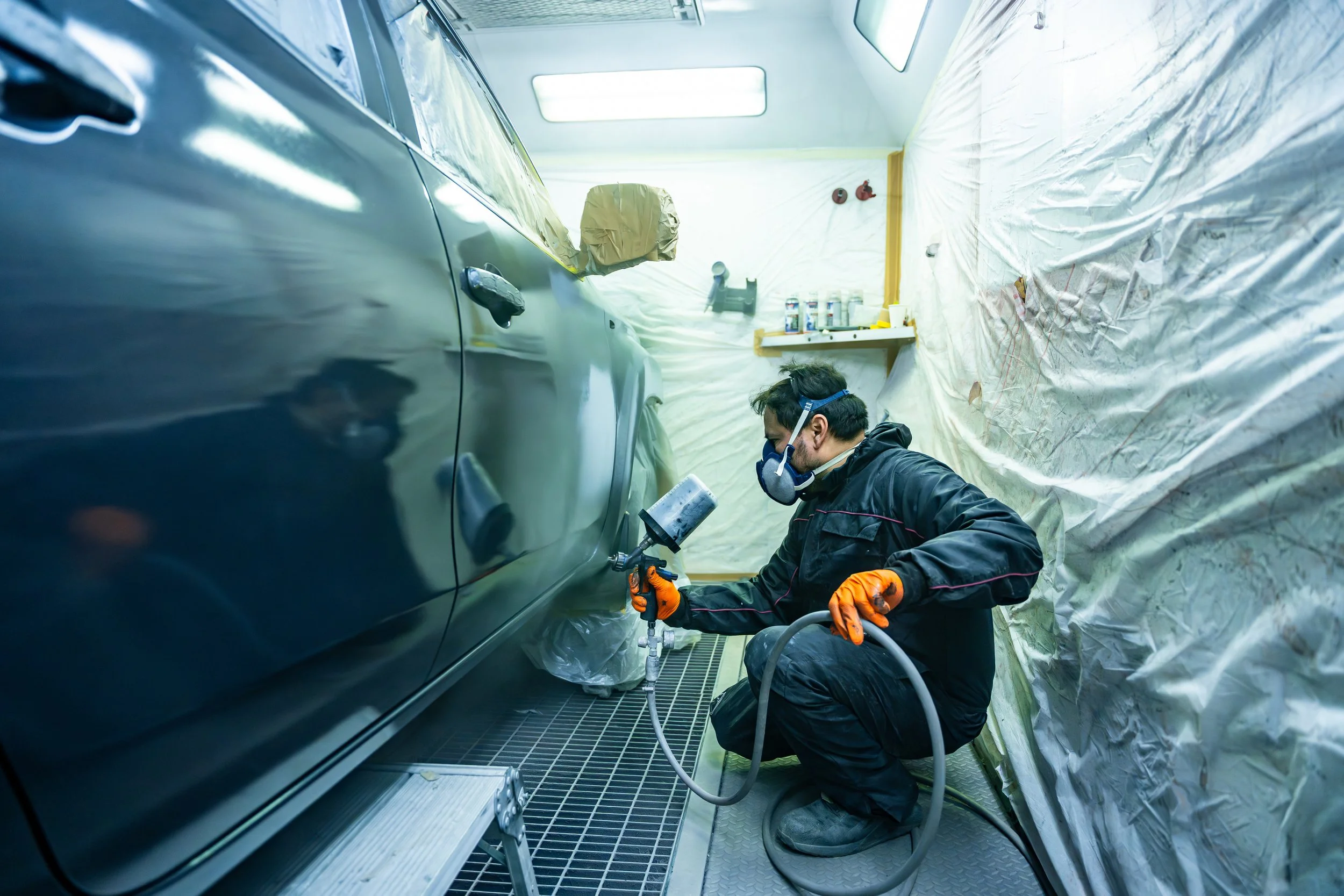Technician repairing a modern vehicle with sensor technology that raises auto repair costs