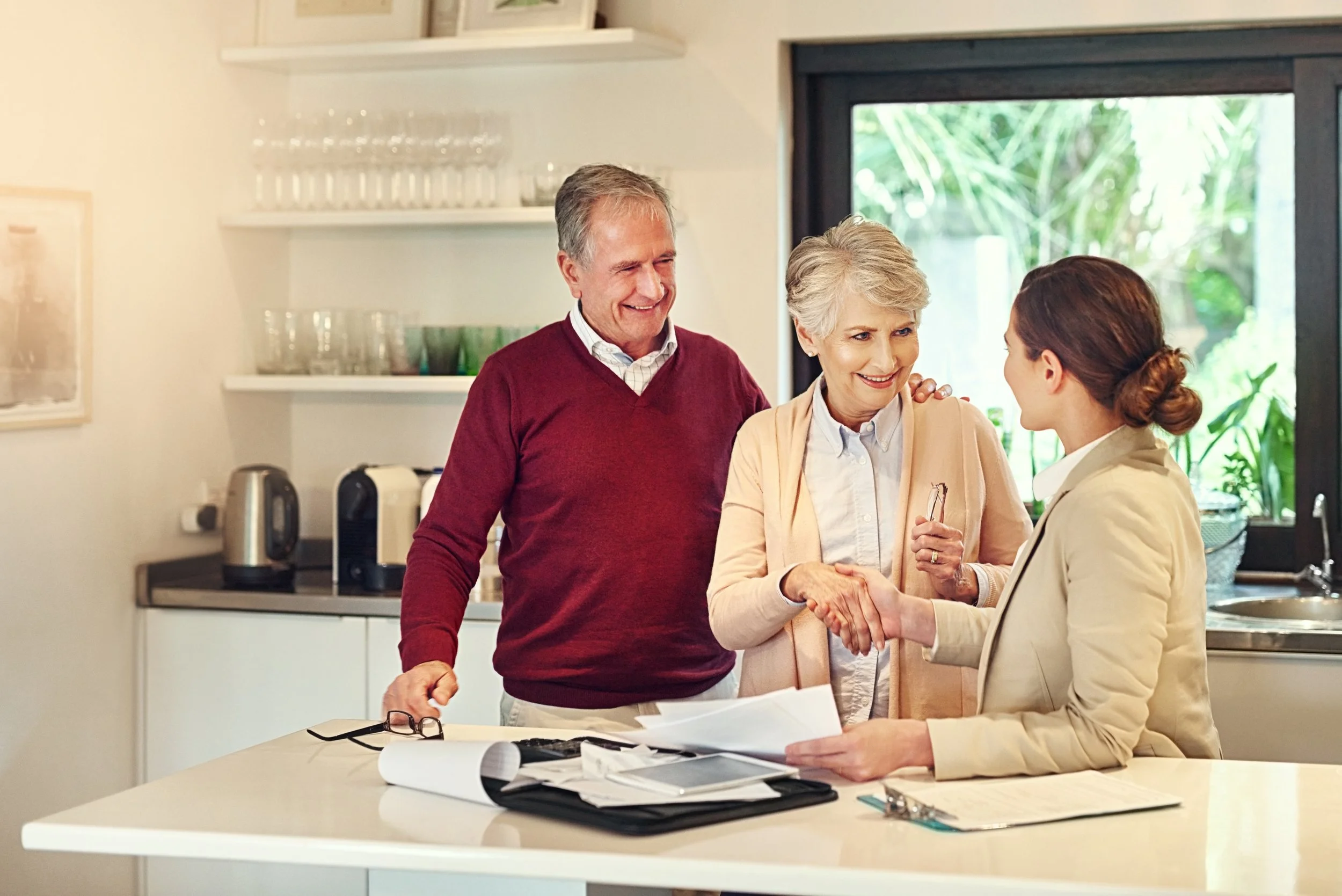 An insurance agent meeting with a couple to discuss retirement coverage options.