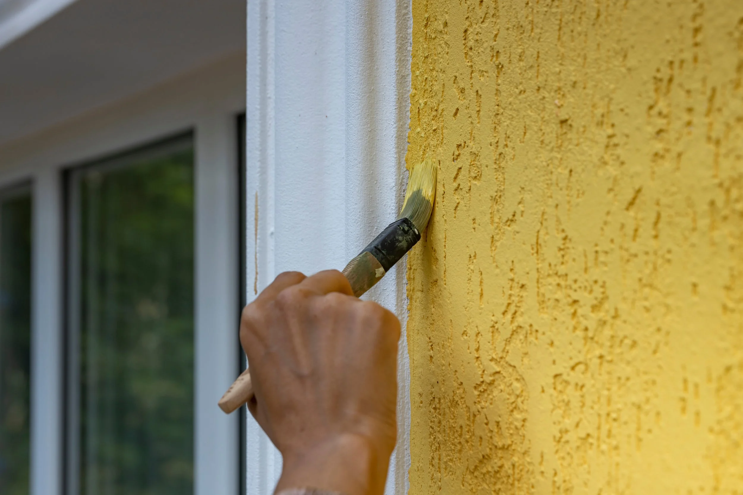 Homeowner painting an exterior that may require HOA approval under community restrictions