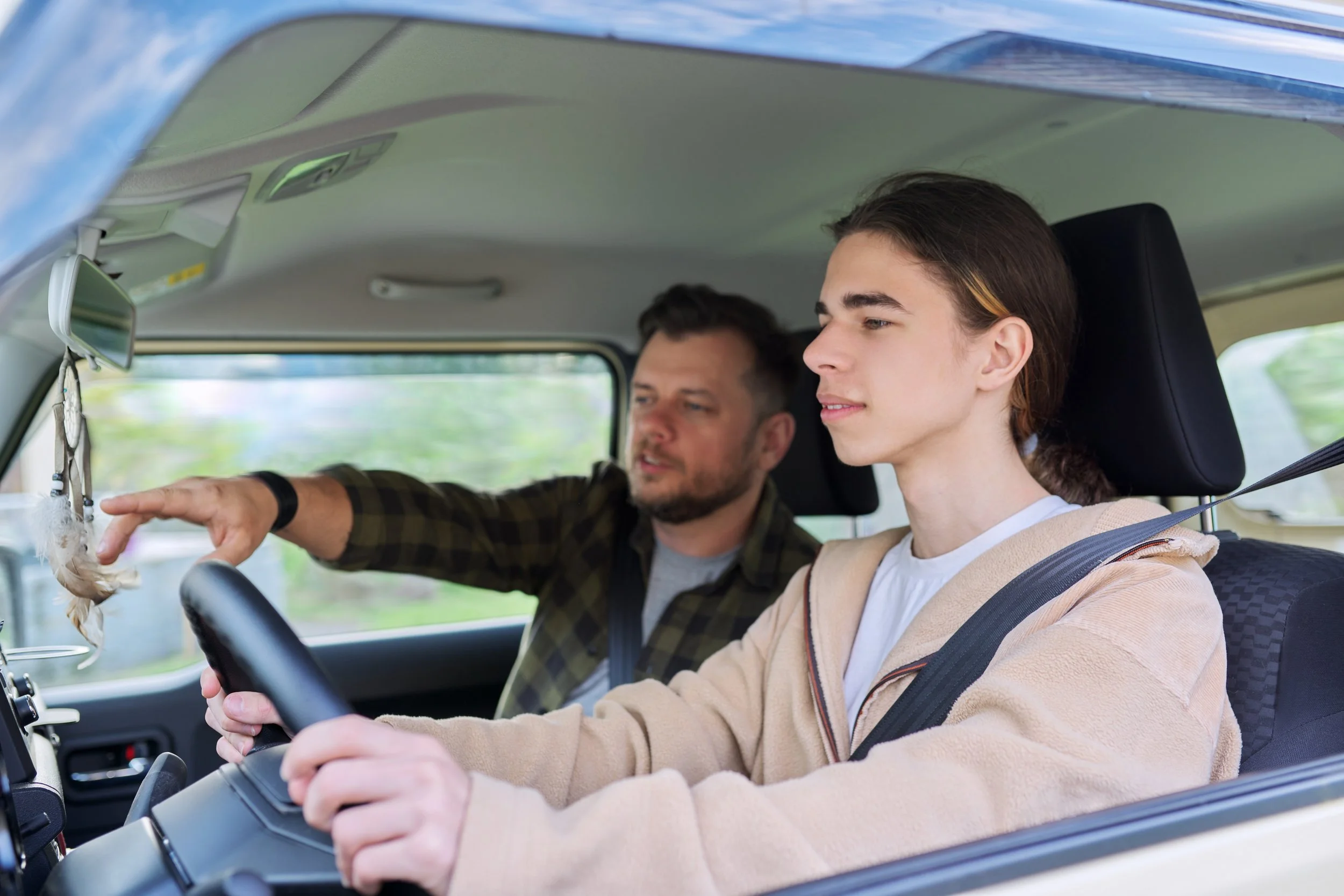 Parent and young adult reviewing auto insurance paperwork before adding a new driver to the policy