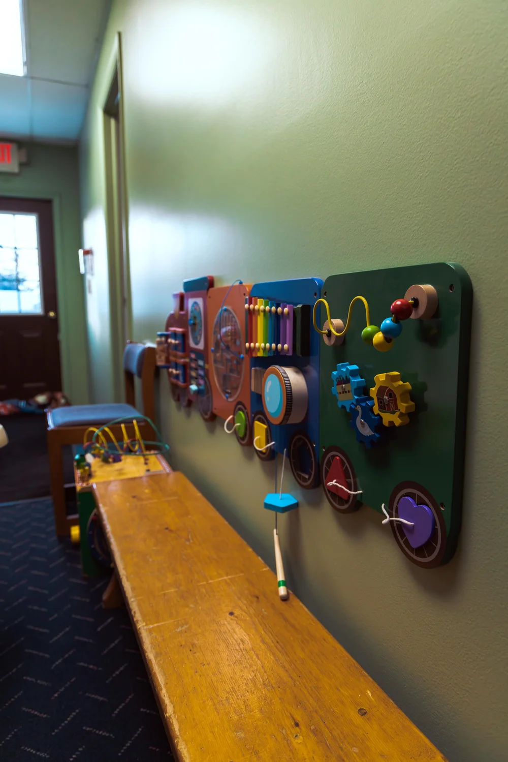 Hands-on activity wall with gears, beads, and a xylophone