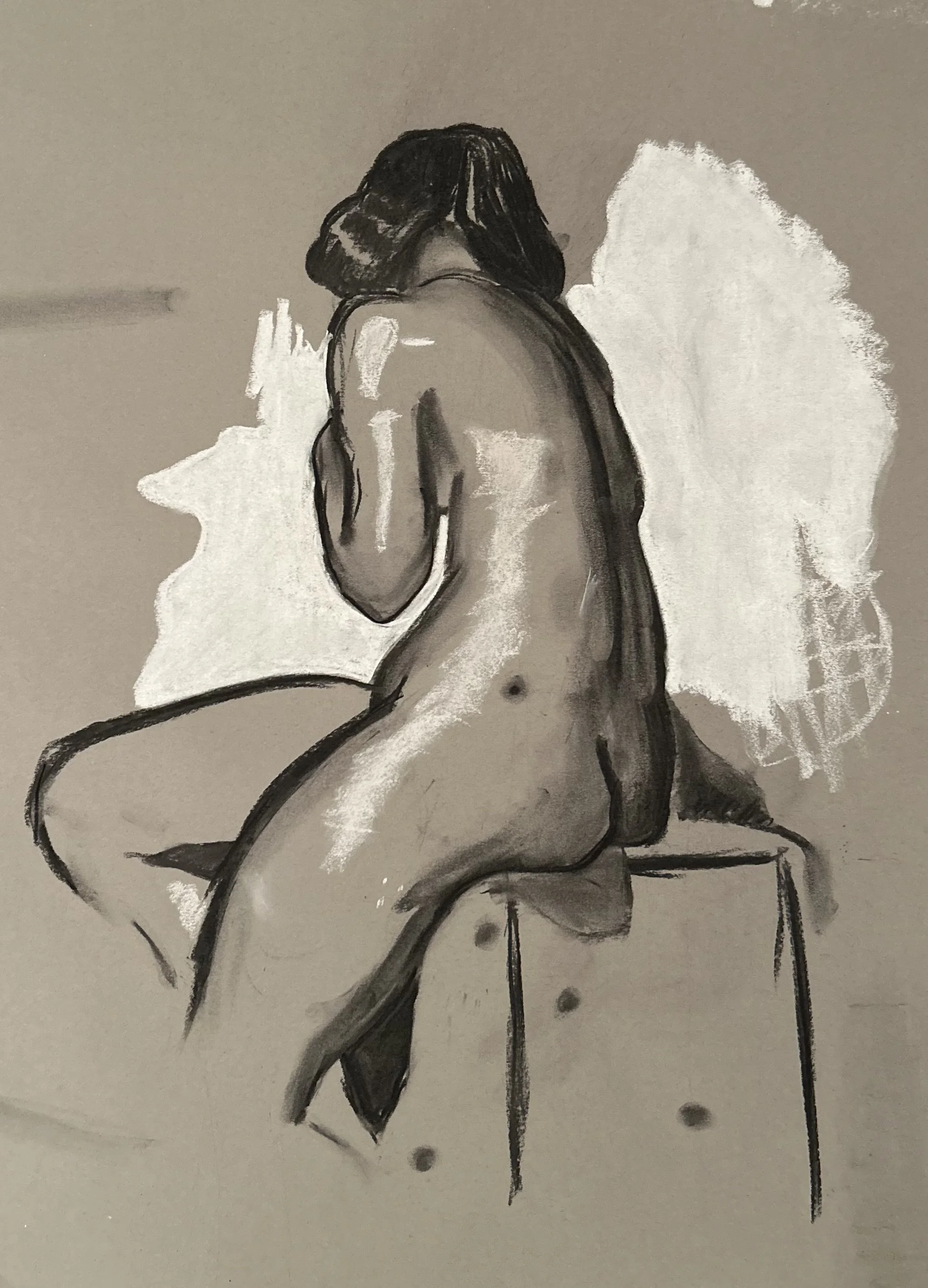 Charcoal drawing of a nude figure sitting with back turned.
