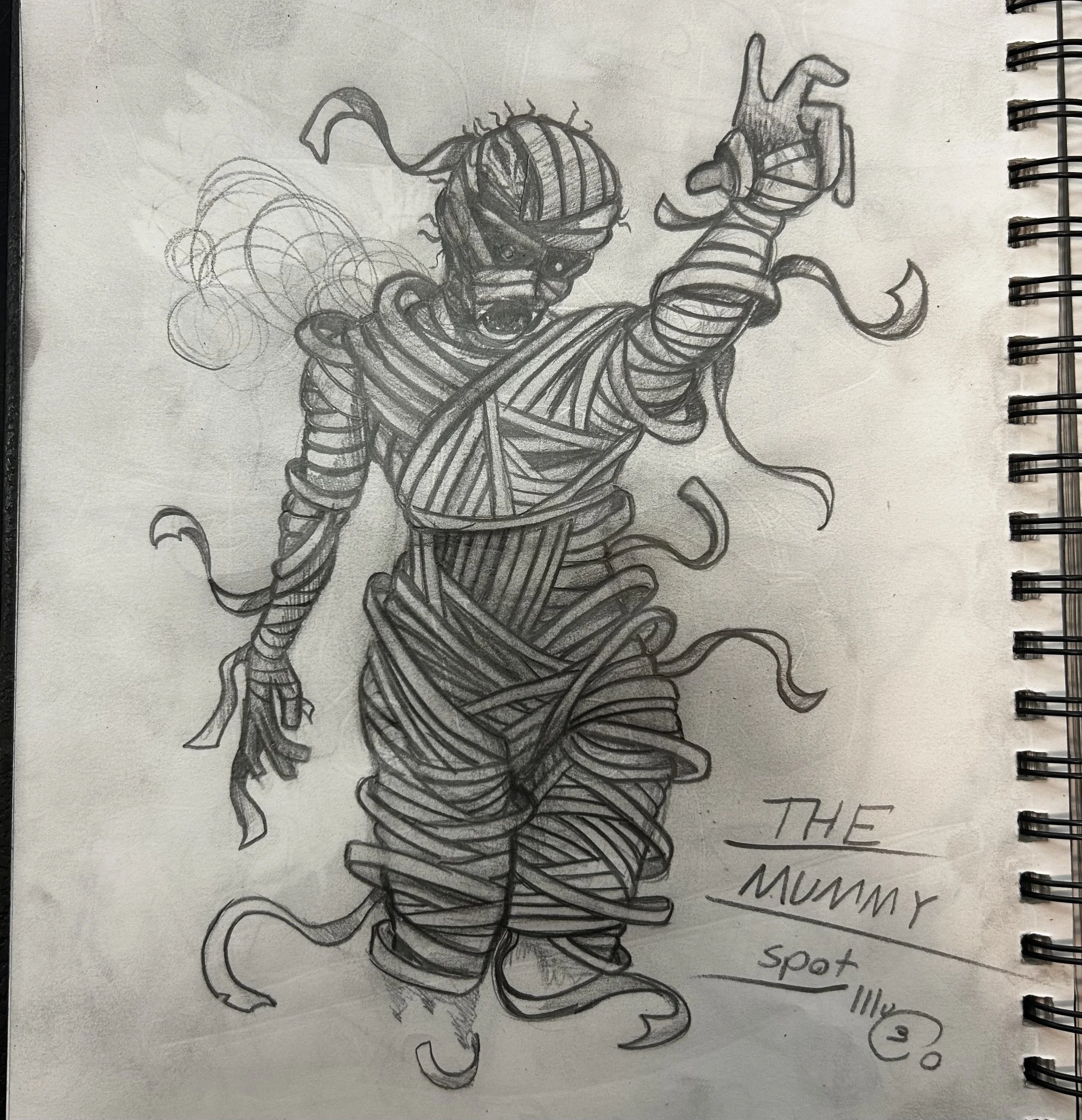 Pencil drawing of a mummy with bandages unraveling, raising one arm with an open mouth, on a sketchbook page. "The Mummy" is written near the bottom in cursive.