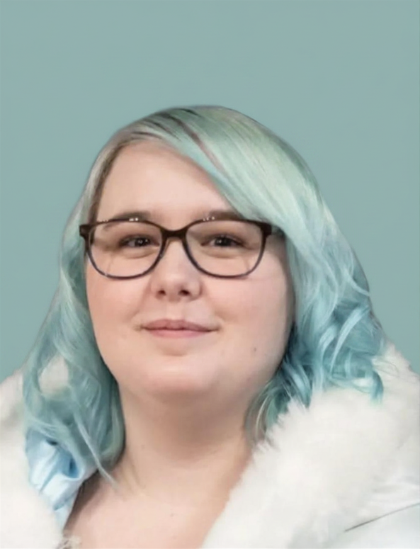 Close-up portrait of a woman with pastel blue and green hair, wearing glasses and a white fur coat, against a light blue background.