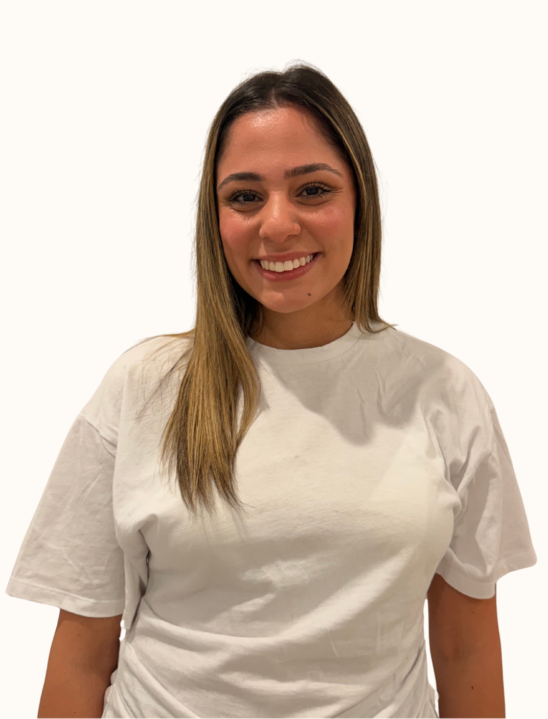 A young woman with long, light brown hair smiling while wearing a white t-shirt, standing against a plain white background.