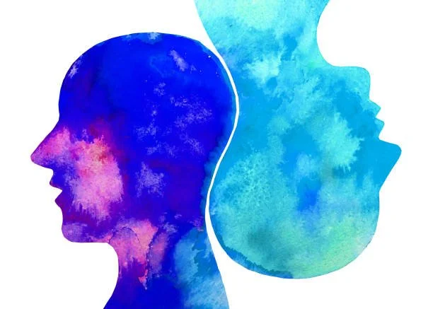 Two human head silhouettes facing away from each other with blue watercolor textures.