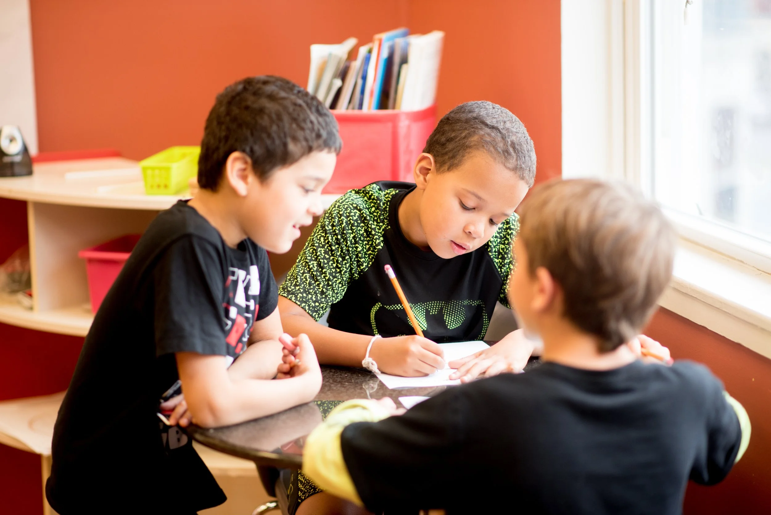 three boys doing schoolwork