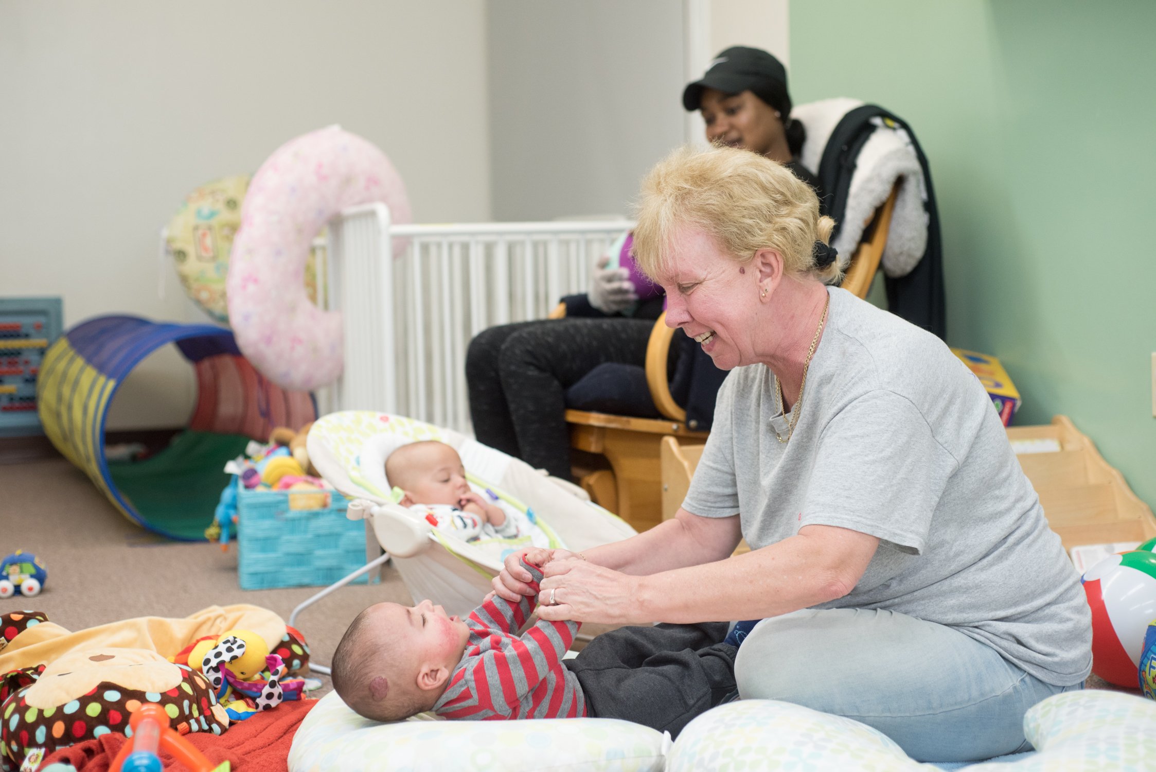Gregg House worker playing with infant