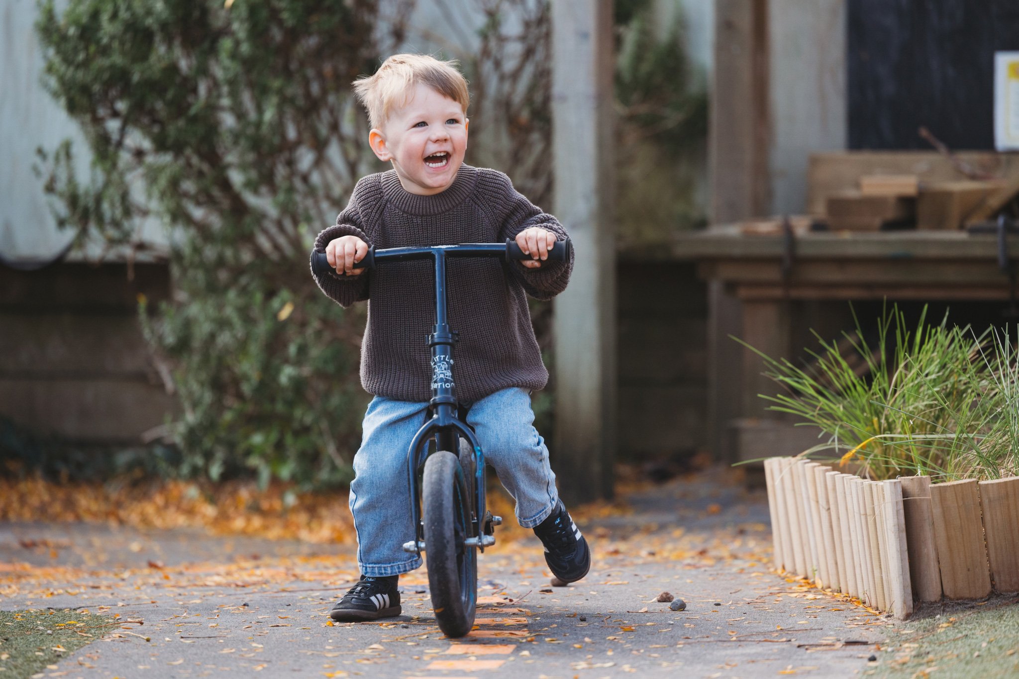 Boy riding his balance bike at Spotted Frog, kindergarten in Mangere Bridge, South Auckland