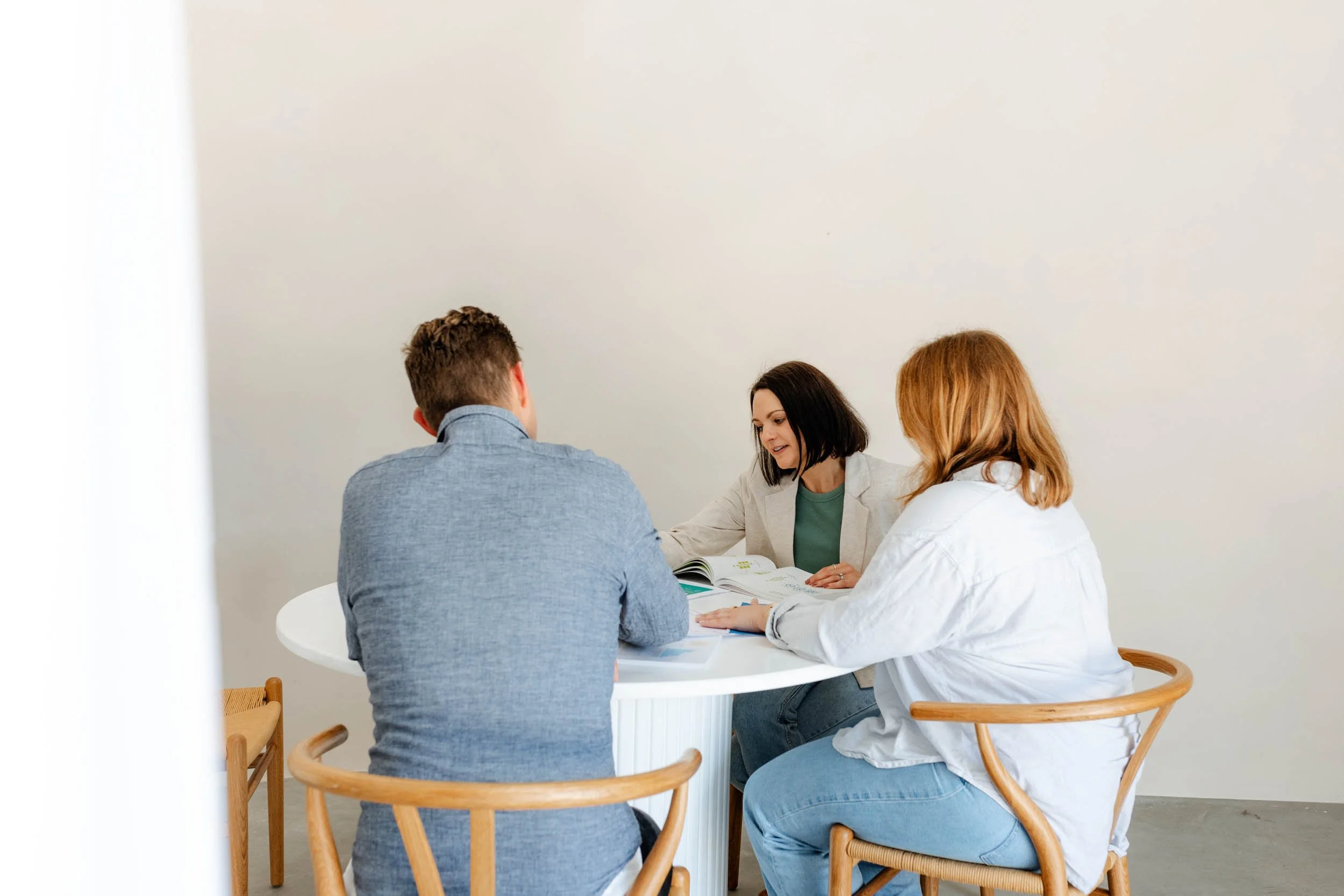 Three people collaborating around a round table