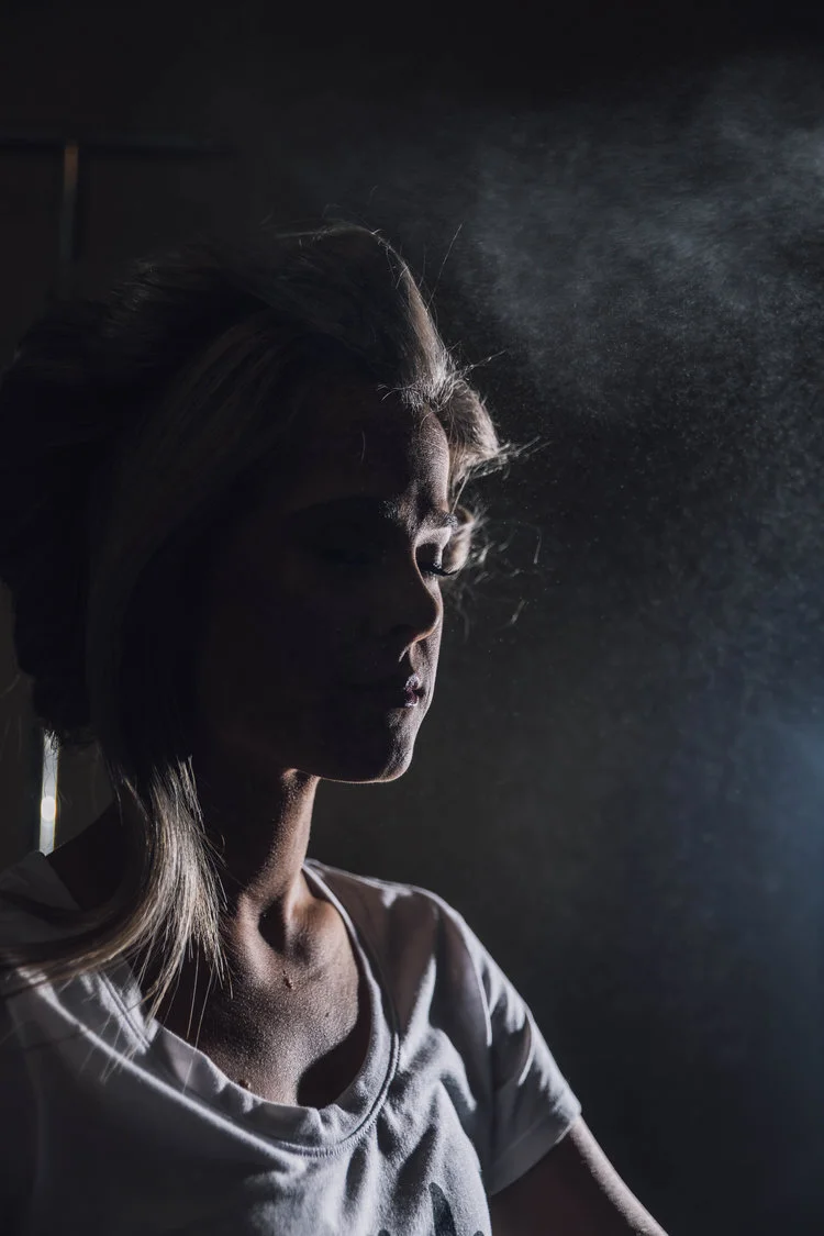 Silhouette of a person with hair styled, backlit by diffuse light.