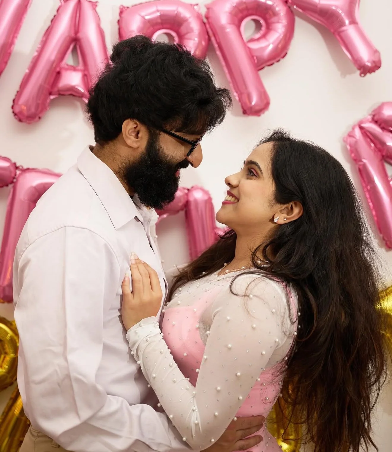 Couple embracing after birthday surprise with romantic balloon backdrop