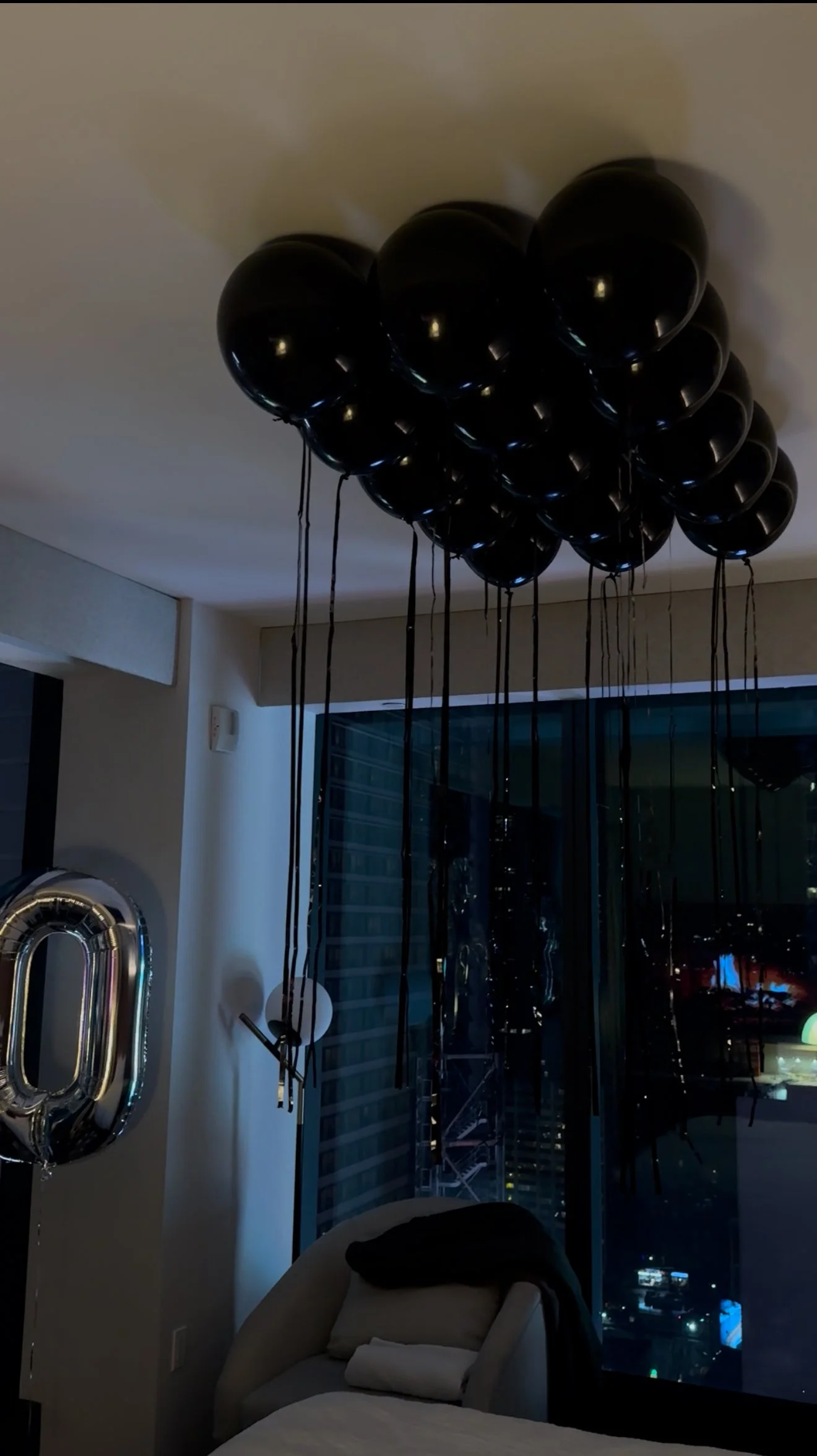Hotel room decorated with black and silver balloons