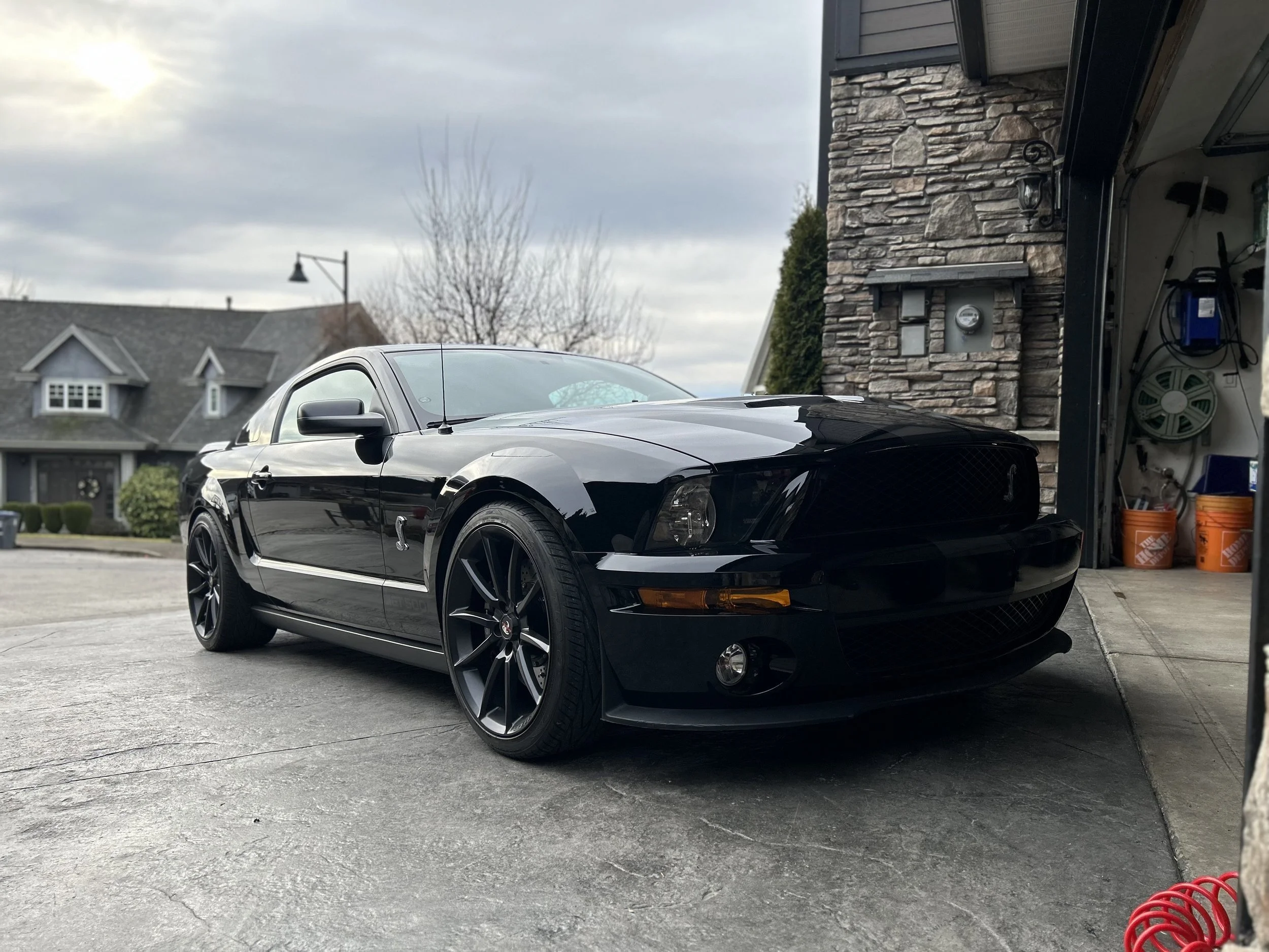 Black Ford Mustang after professional detailing and ceramic coating.