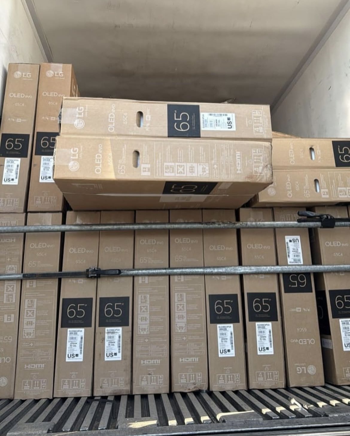 Boxes of LG 65-inch OLED Evo TVs stacked in a truck