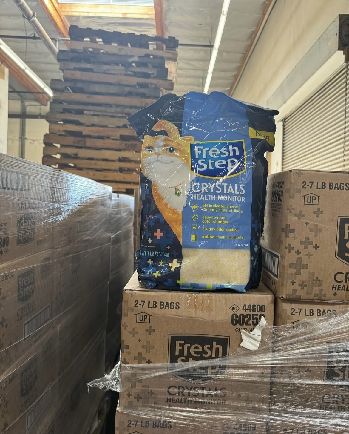 Stack of Fresh Step Crystals cat litter bags on pallets in a warehouse