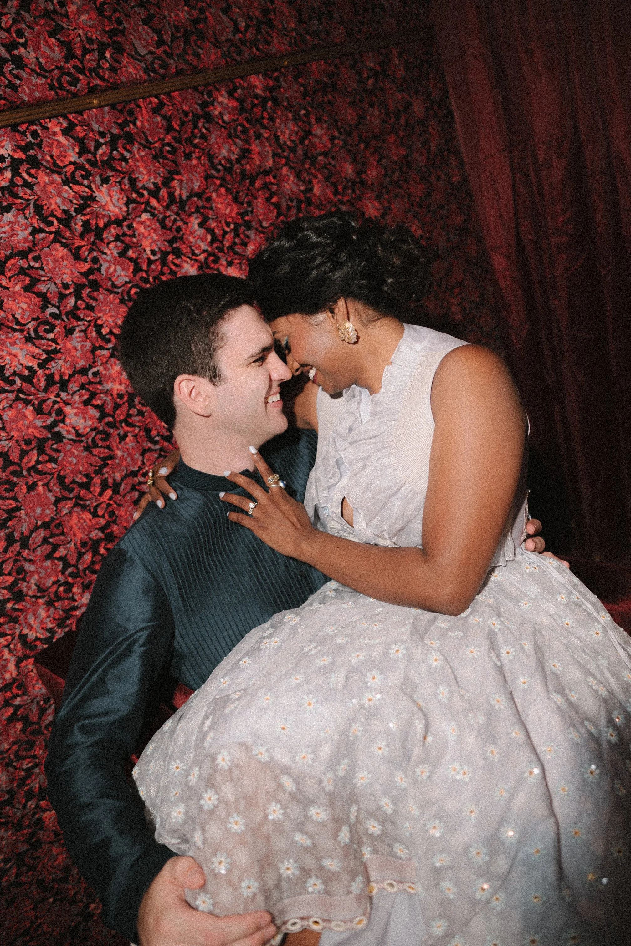 A bride in a wedding dress preparing for her wedding, with another woman adjusting her veil.