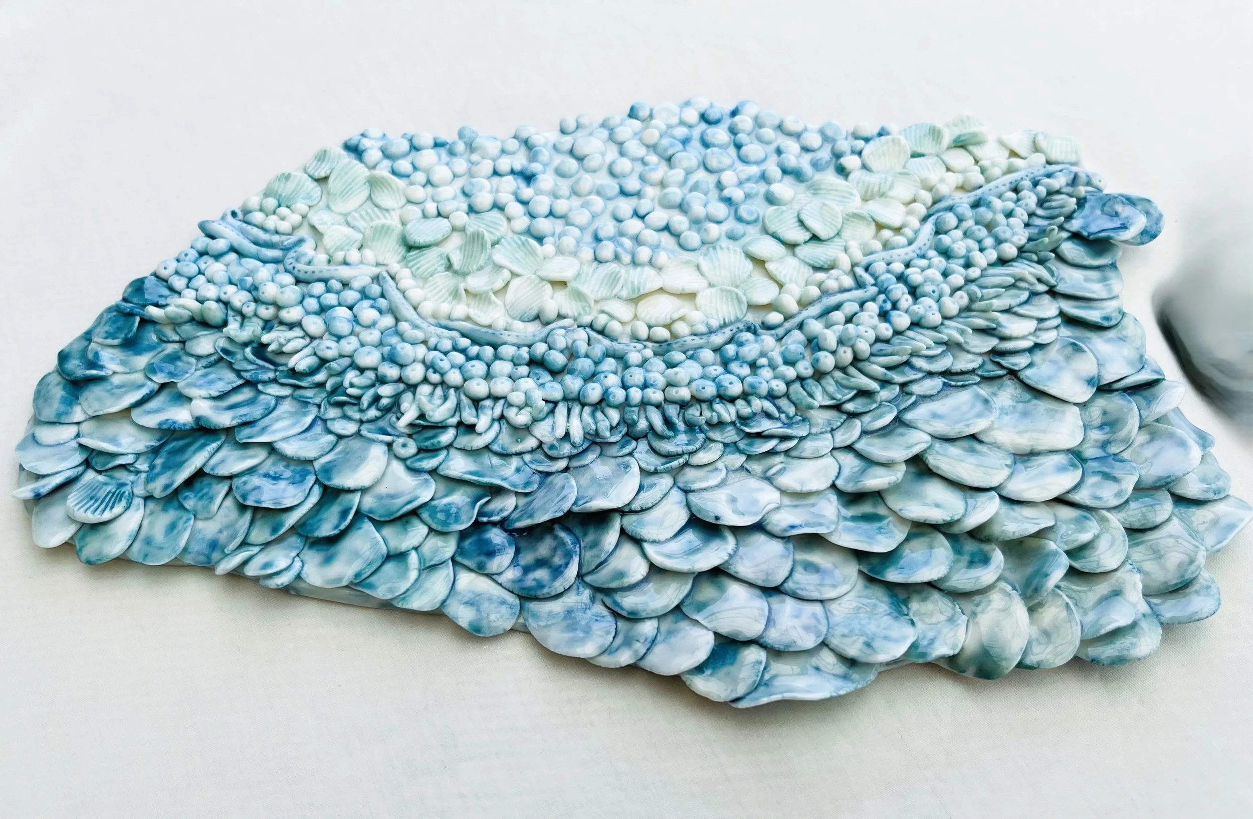 White porcelain, layered in the current of the ocean. Blue, green Aqua and white. Wall hanging In a set or as a single.