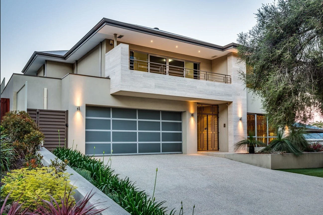 Modern two-story suburban house with a spacious driveway, double garage, and neatly landscaped front yard.