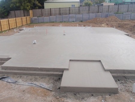 Concrete slab foundation at a construction site with plumbing