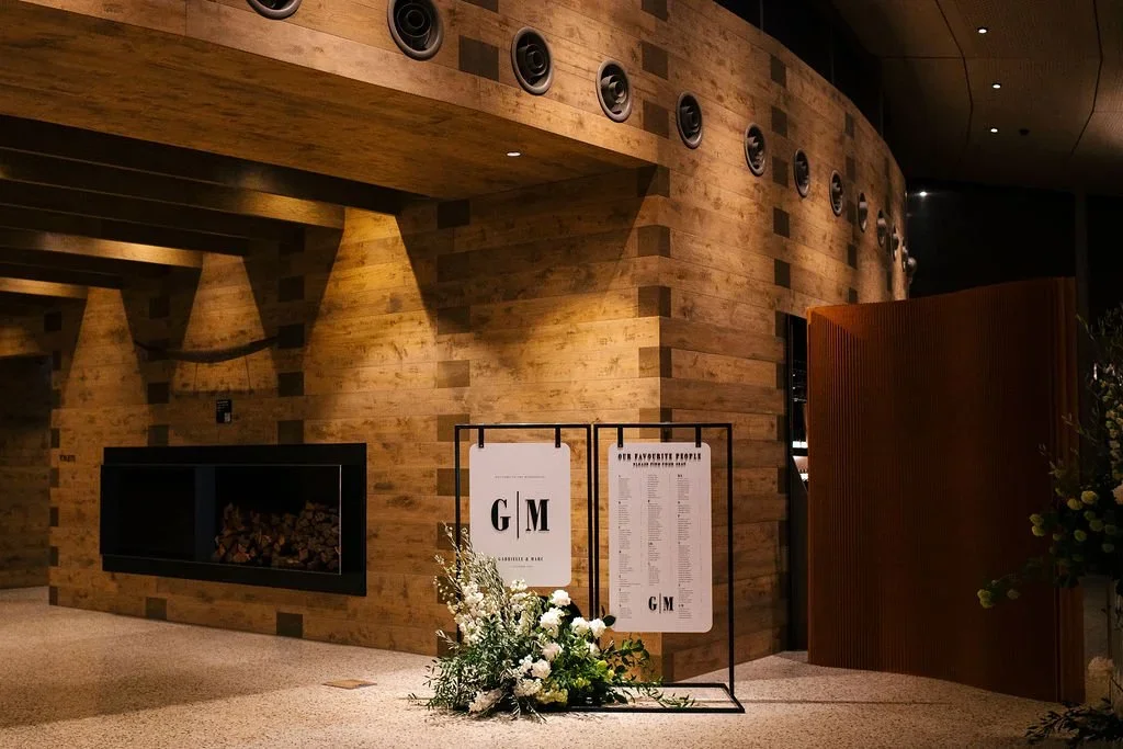 Point Leo Estate wedding signage display with white florals and contemporary black metal frames.