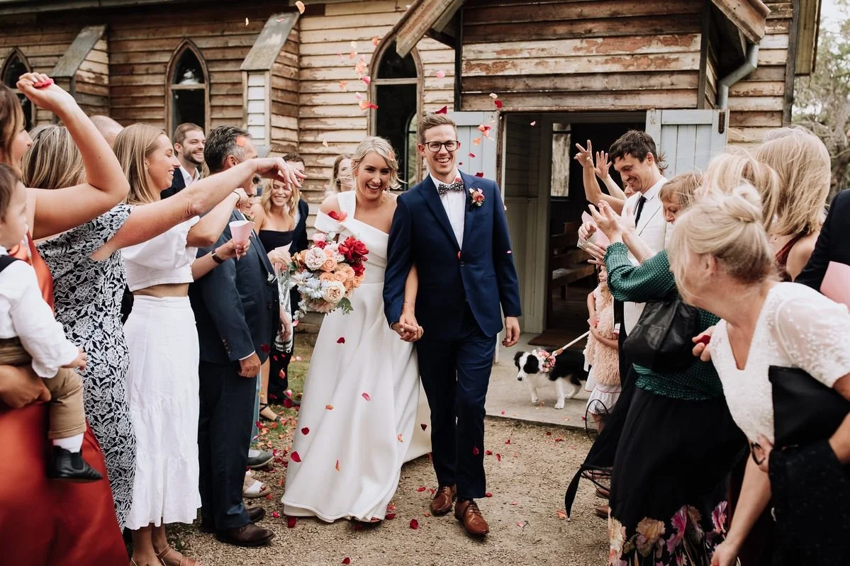 Tanglewood Estate wedding exit with guests throwing petals and the bride holding a Poppy Culture bouquet.