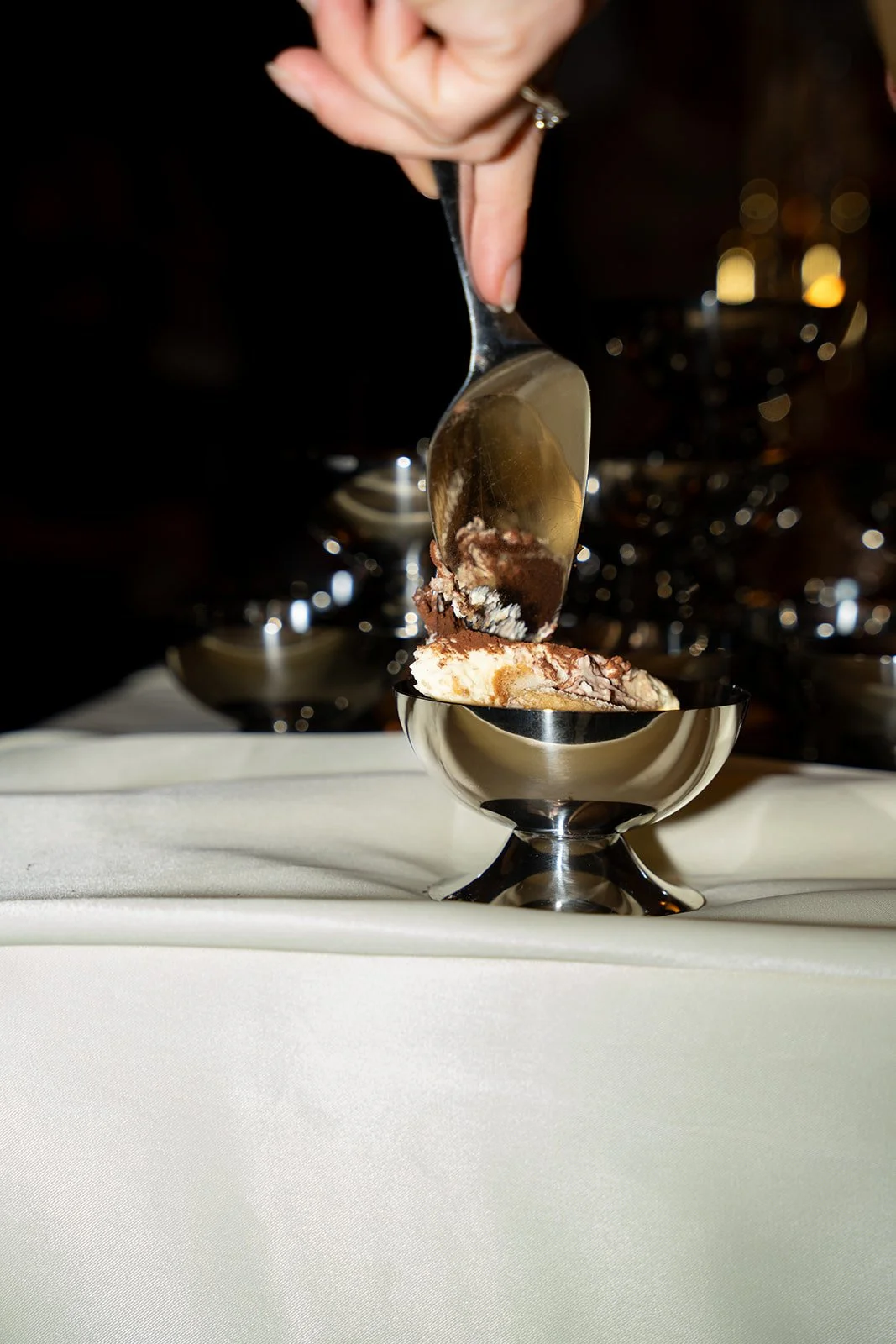 Tiramisu øses op i en sølvskål på et hvidt bord ved Arturels Silent Club i København