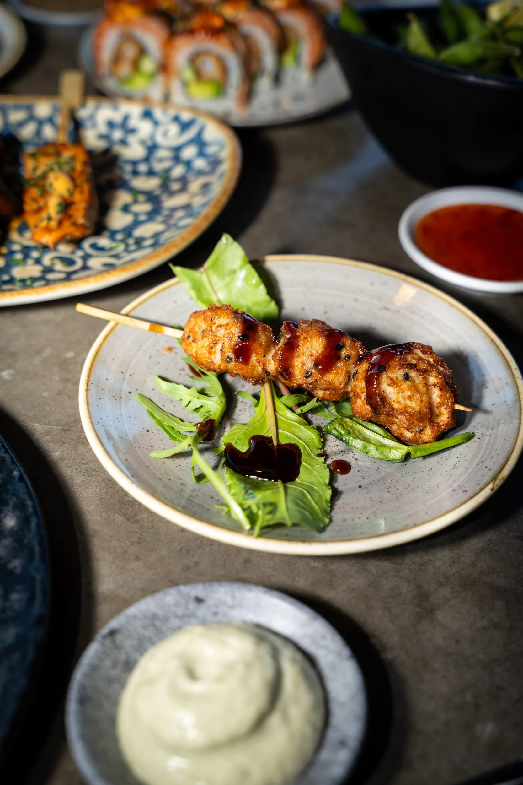 Grillet stick på salatblade med lys dip ved siden af på Sushi Lab København