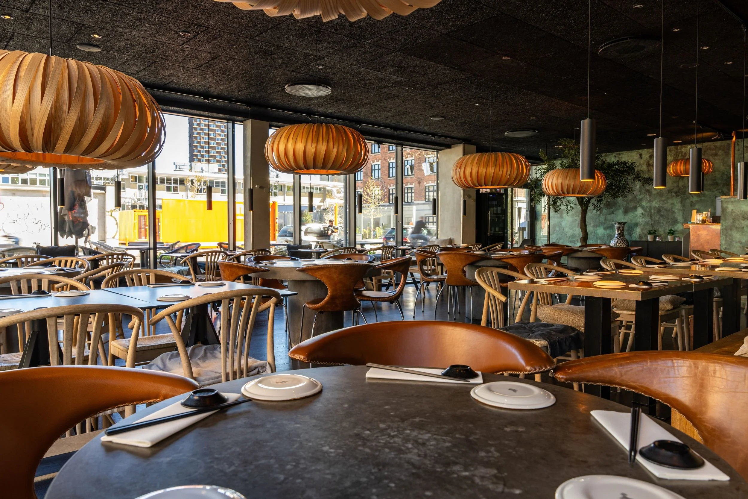 Dækkede mørke borde og træstole i spisesalen hos Sushi Lab København