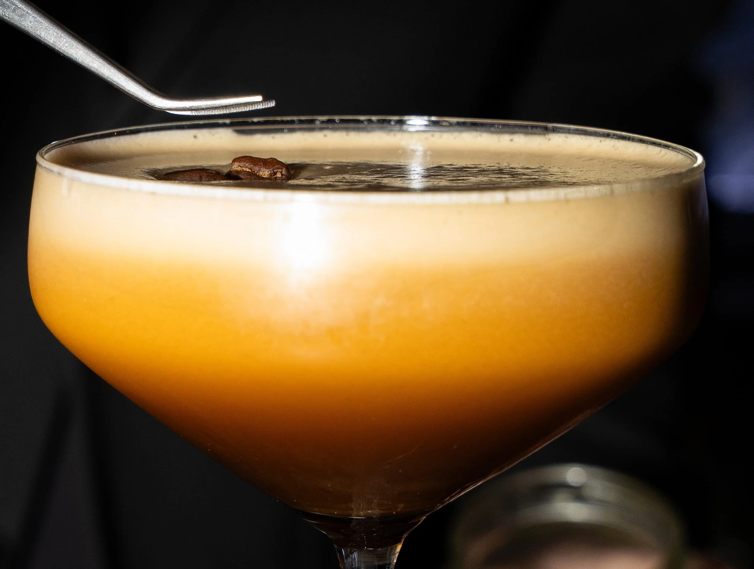 Nærbillede af skummende cocktail i coupeglas med pynt hos Little Green Door København