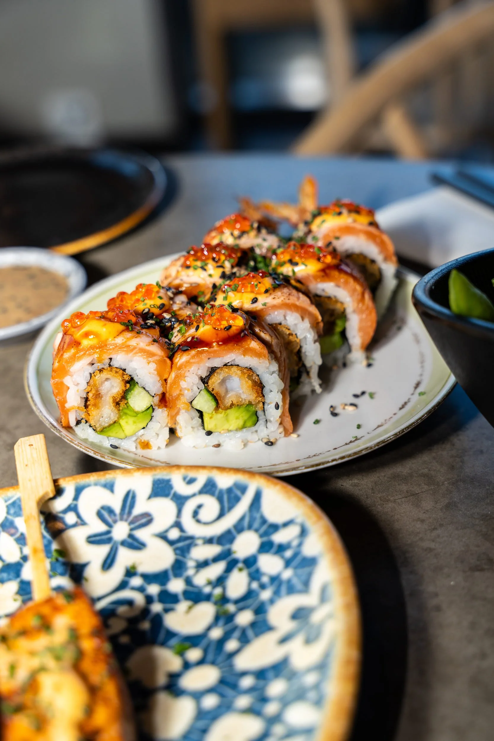 Flamberede laksemaki med sesam og sauce på blåmønstret tallerken hos Sushi Lab
