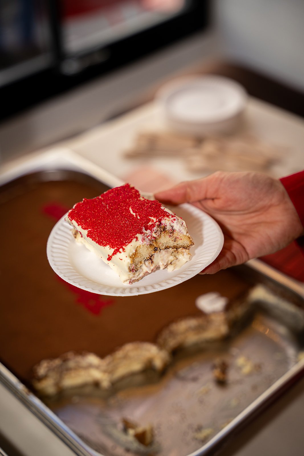 Et stykke tiramisu løftes op på en tallerken over bakken hos Flan