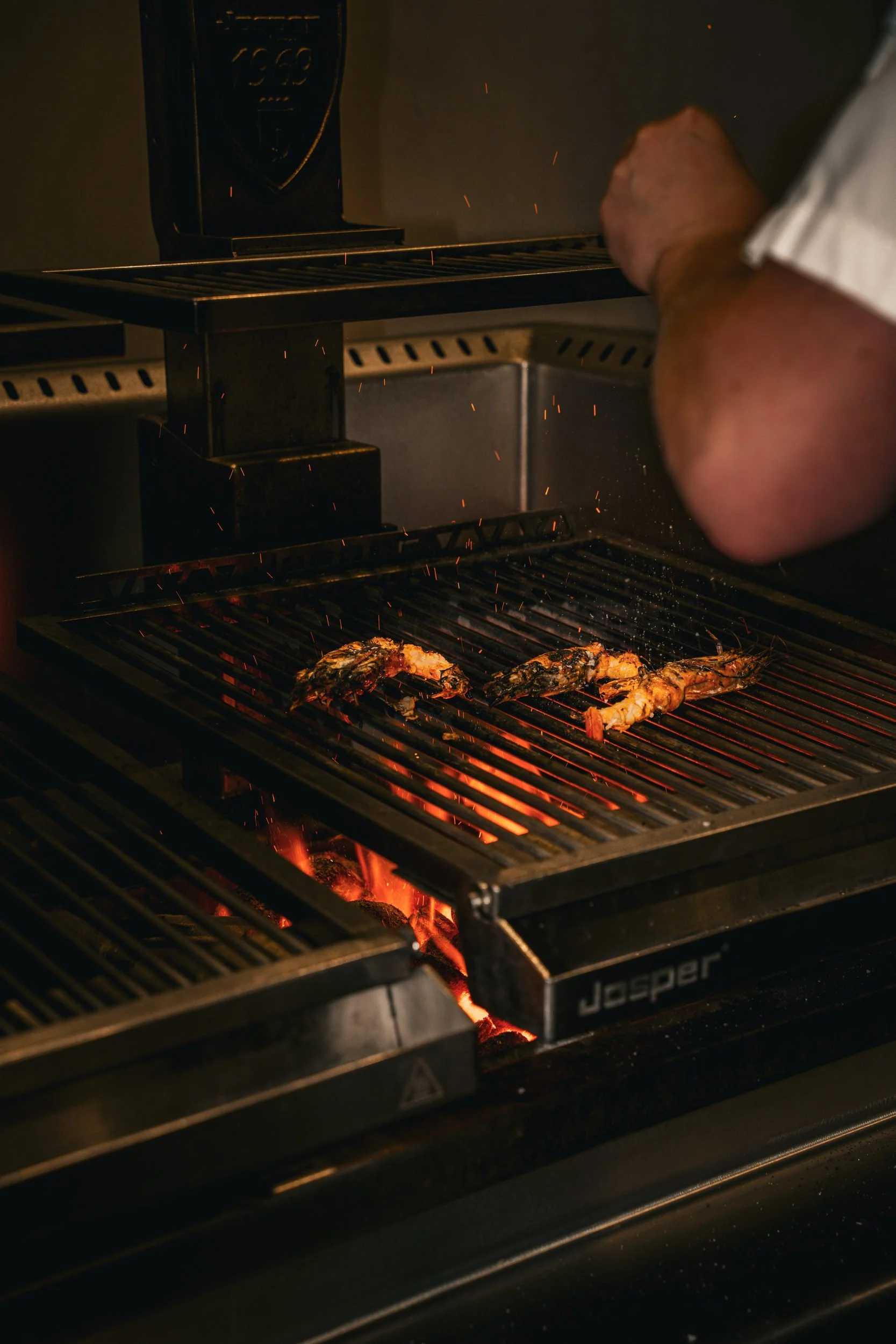 Bøf på kulgrillen med glødende kul under risten hos A Hereford Beefstouw