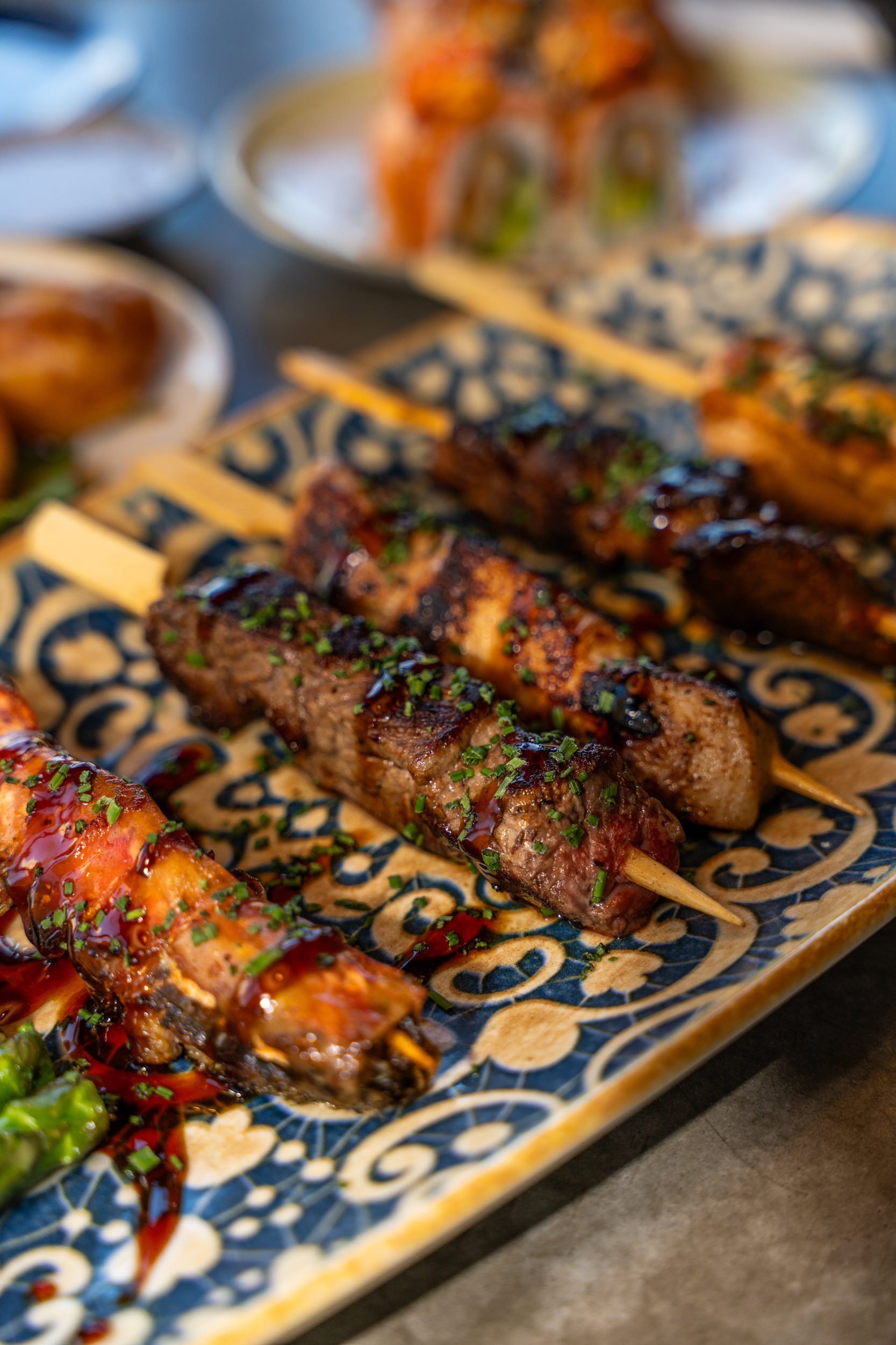 Glaserede grillede sticks på blåmønstret fad hos Sushi Lab København