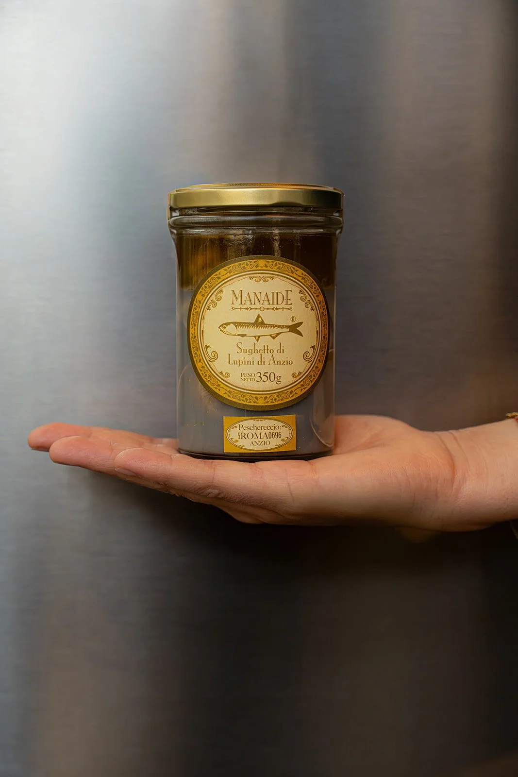 Glas med italiensk delikatesse holdes frem i en åben hånd hos Il Mattarello