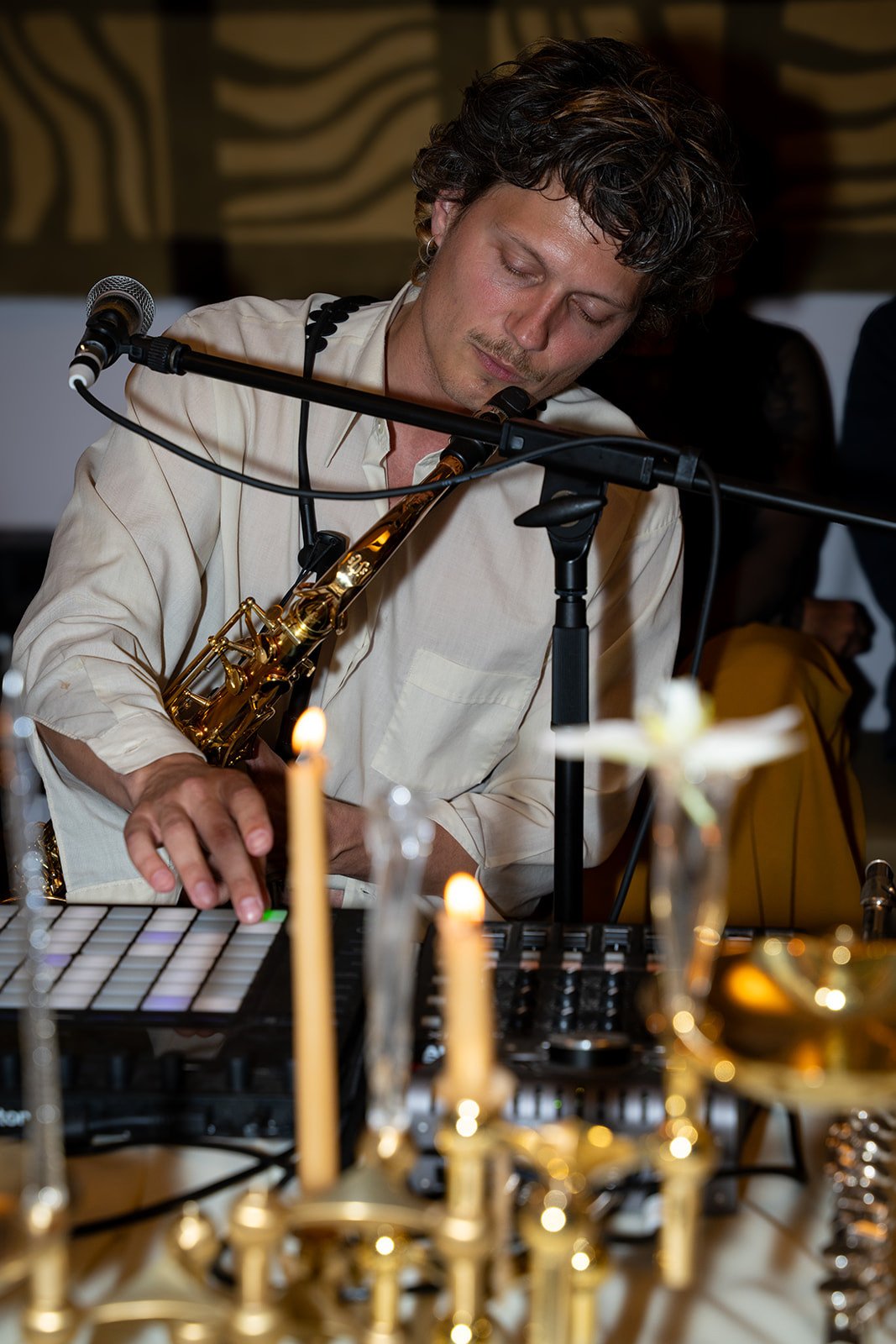 Saxofonist spiller ved levende lys under tiramisu-eventet hos Arturels Silent Club